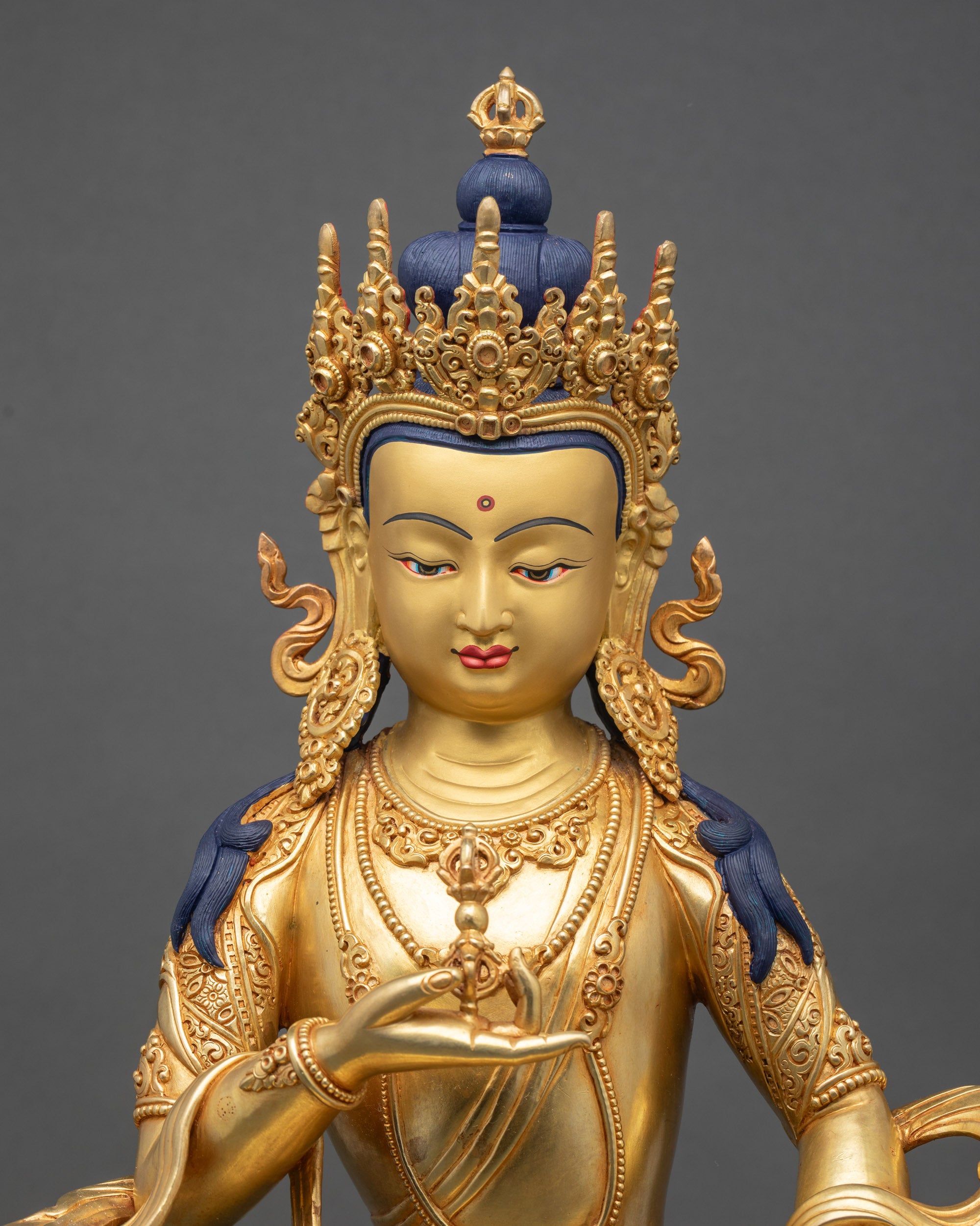 Close-up of Vajrasattva face with gold paint and detailed Himalayan craftsmanship