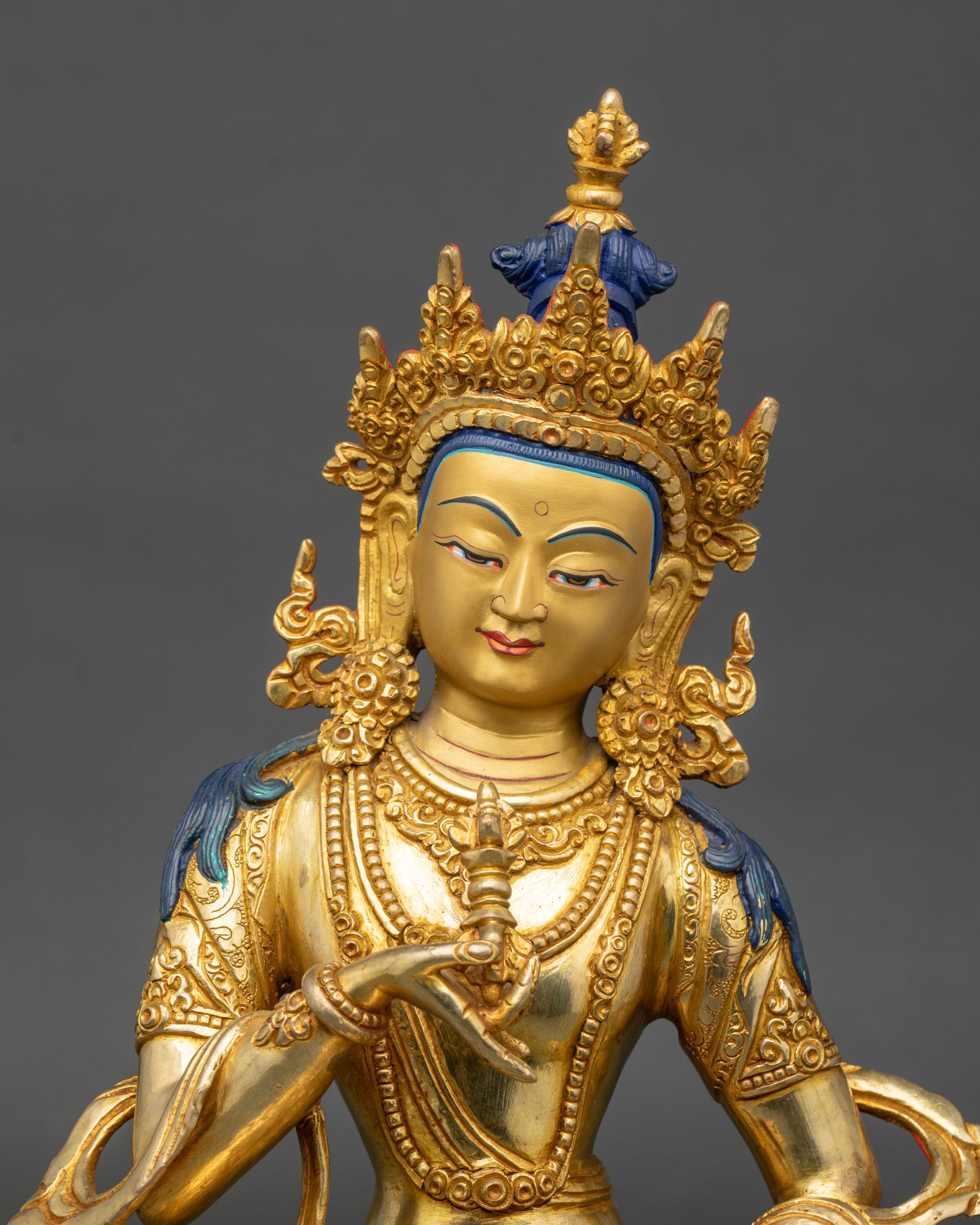 Close-up of Vajrasattva statue showing gold fire-gilded face and intricate details