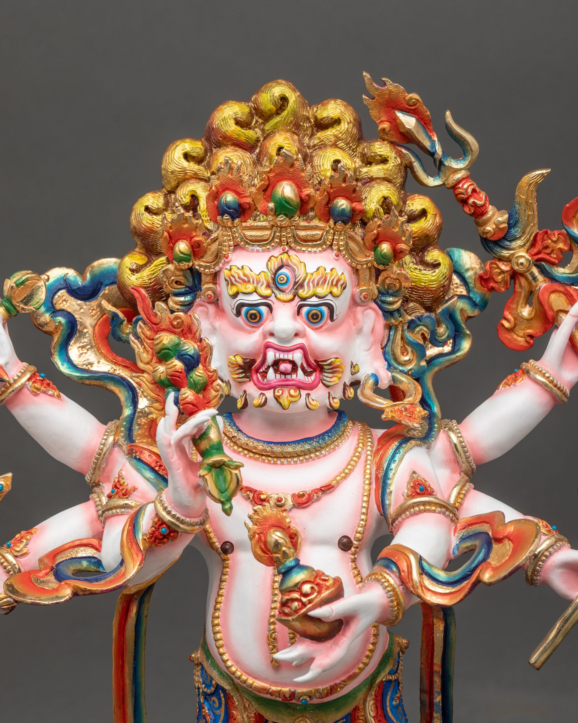 Close-up of White Mahakala holding sacred objects adorned with semi-precious stones