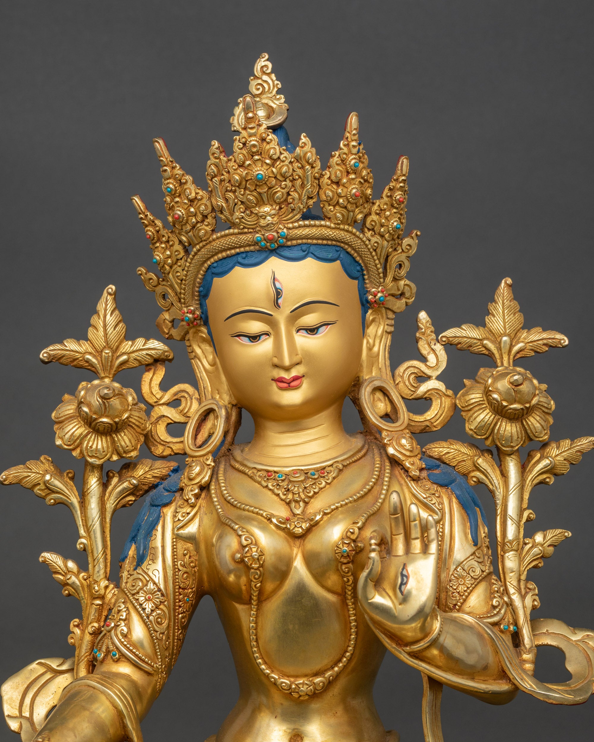 Close-up of White Tara meditation figurine showing detailed copper and gold finish