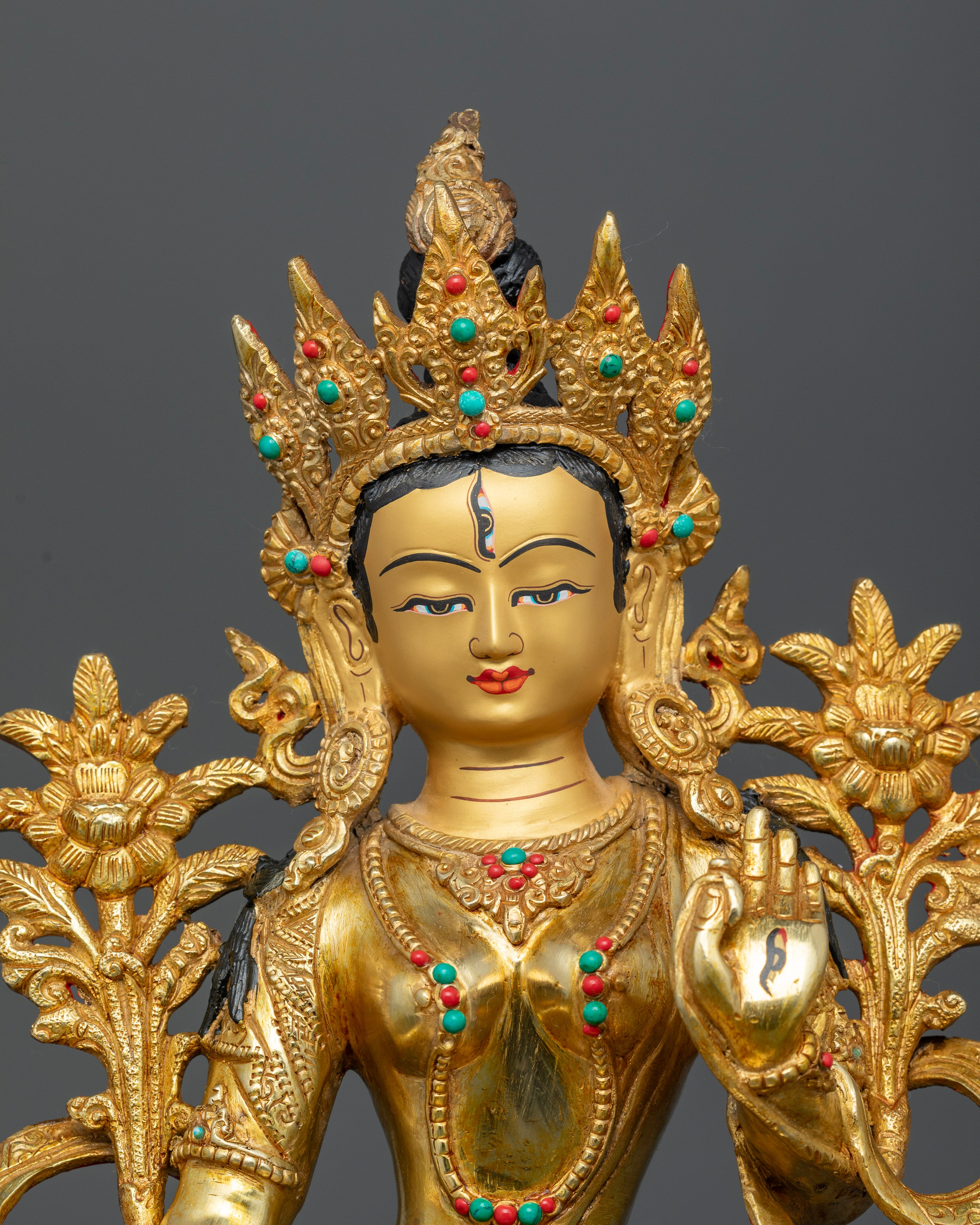 Close-up of White Tara’s face showing 24K gold-painted features and serene expression