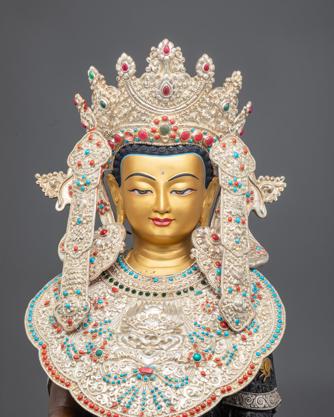 Close-up of a Jowo Rinpoche statue adorned with semi-precious stones and intricate detailing,