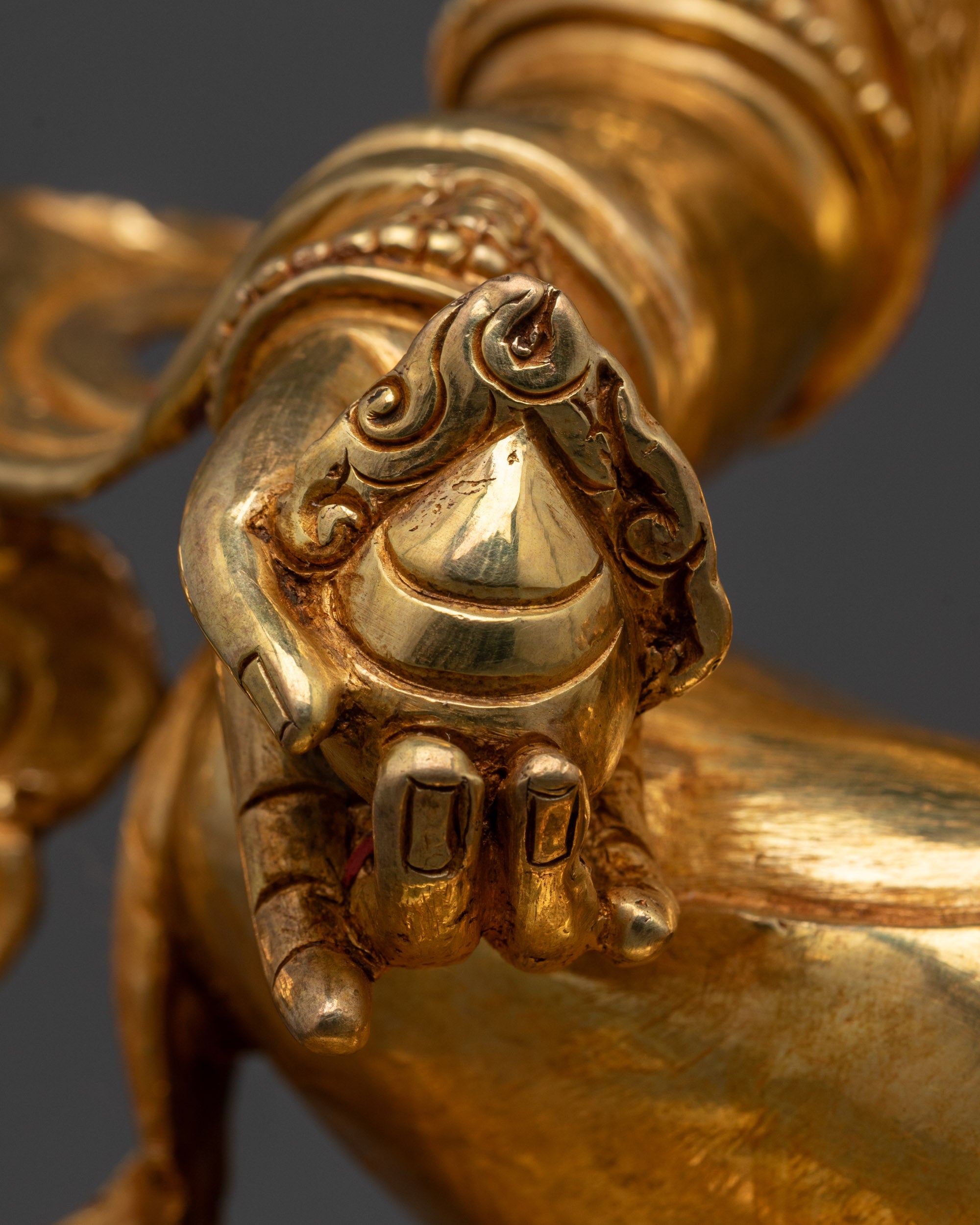Close-up of a gold decorative object with intricate design on a dark background