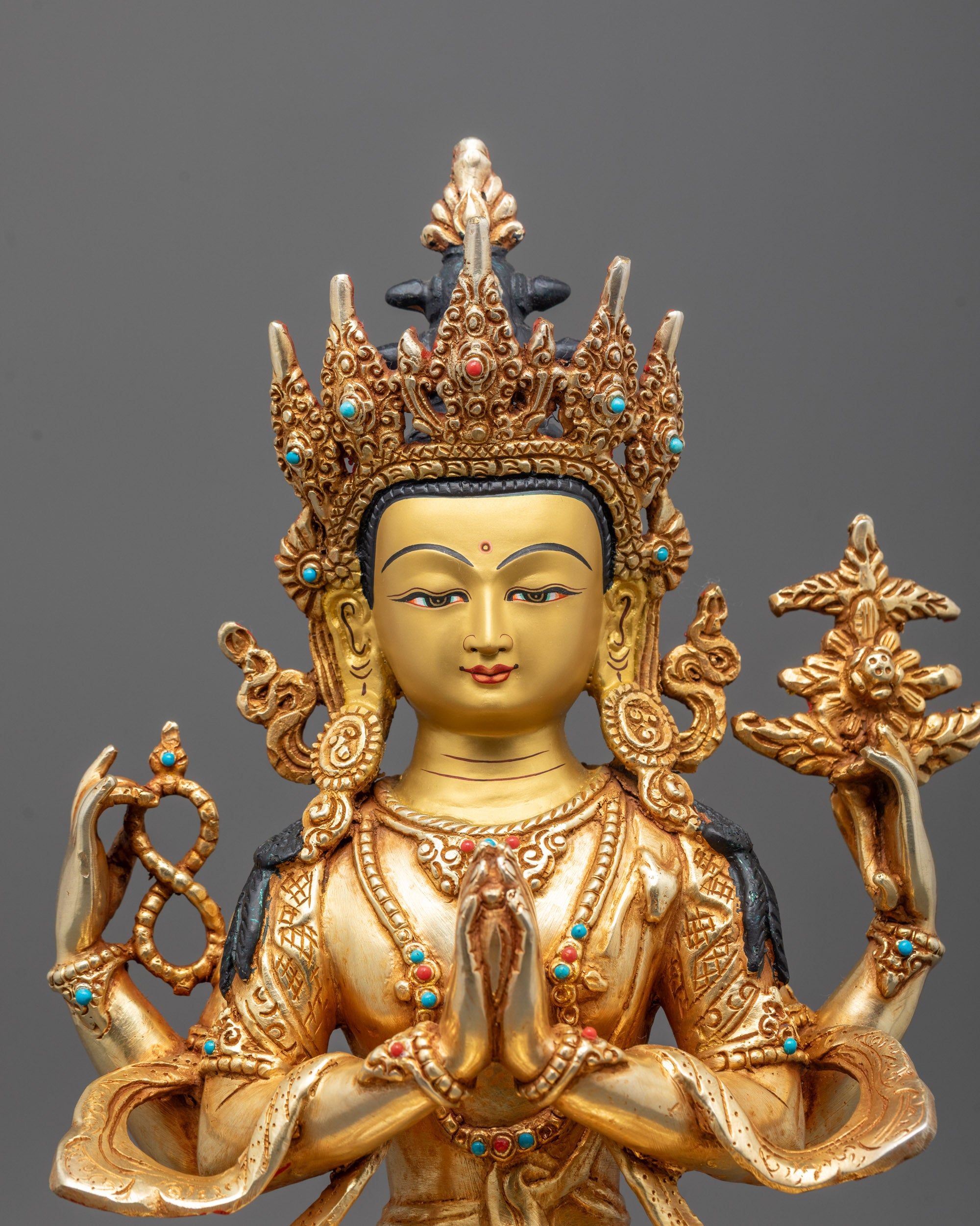 Close-up of fire-gilded detailing on Chenrezig's serene face