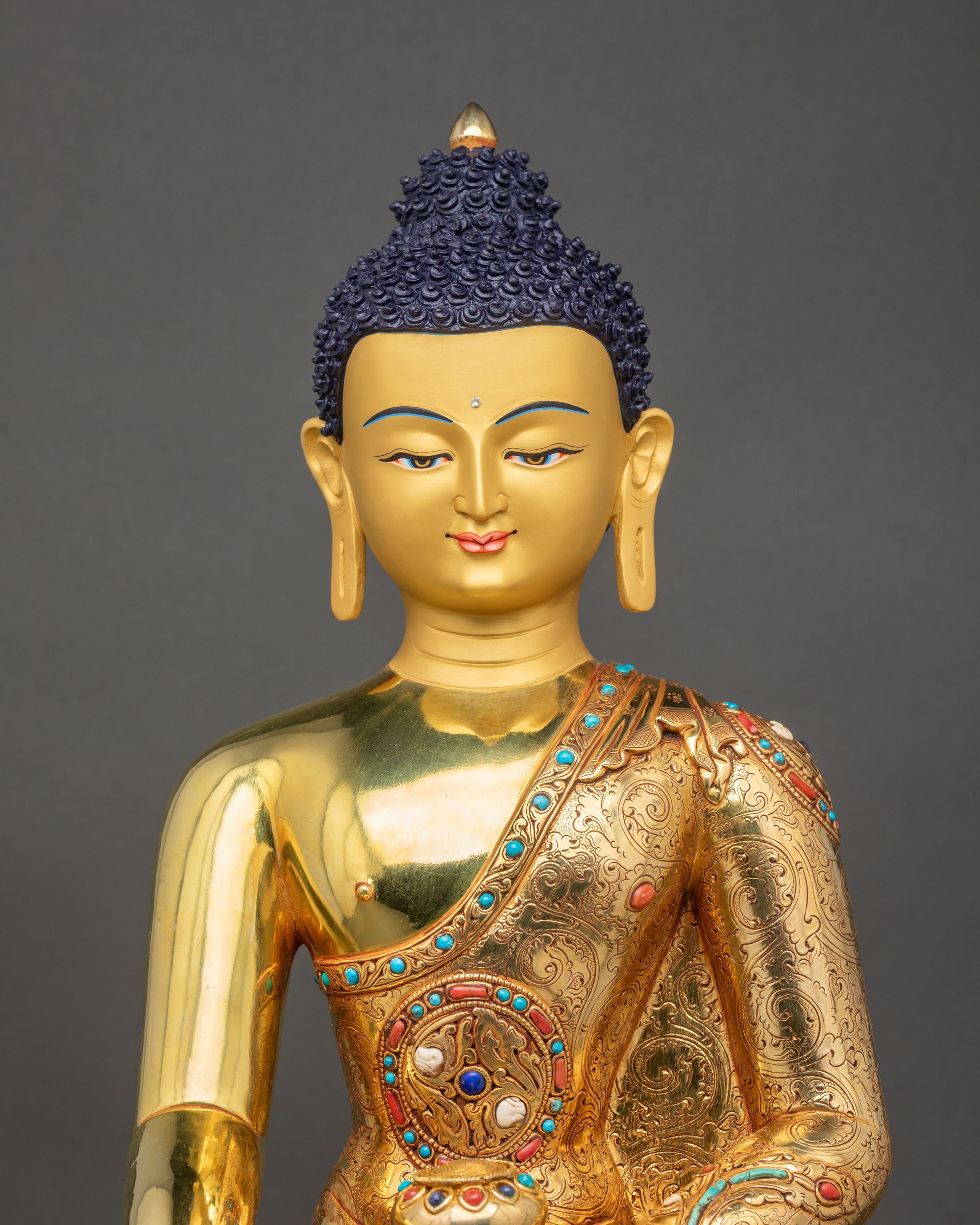 Close-up of handcrafted Shakyamuni Buddha showing gold fire-gilded details and robe carvings