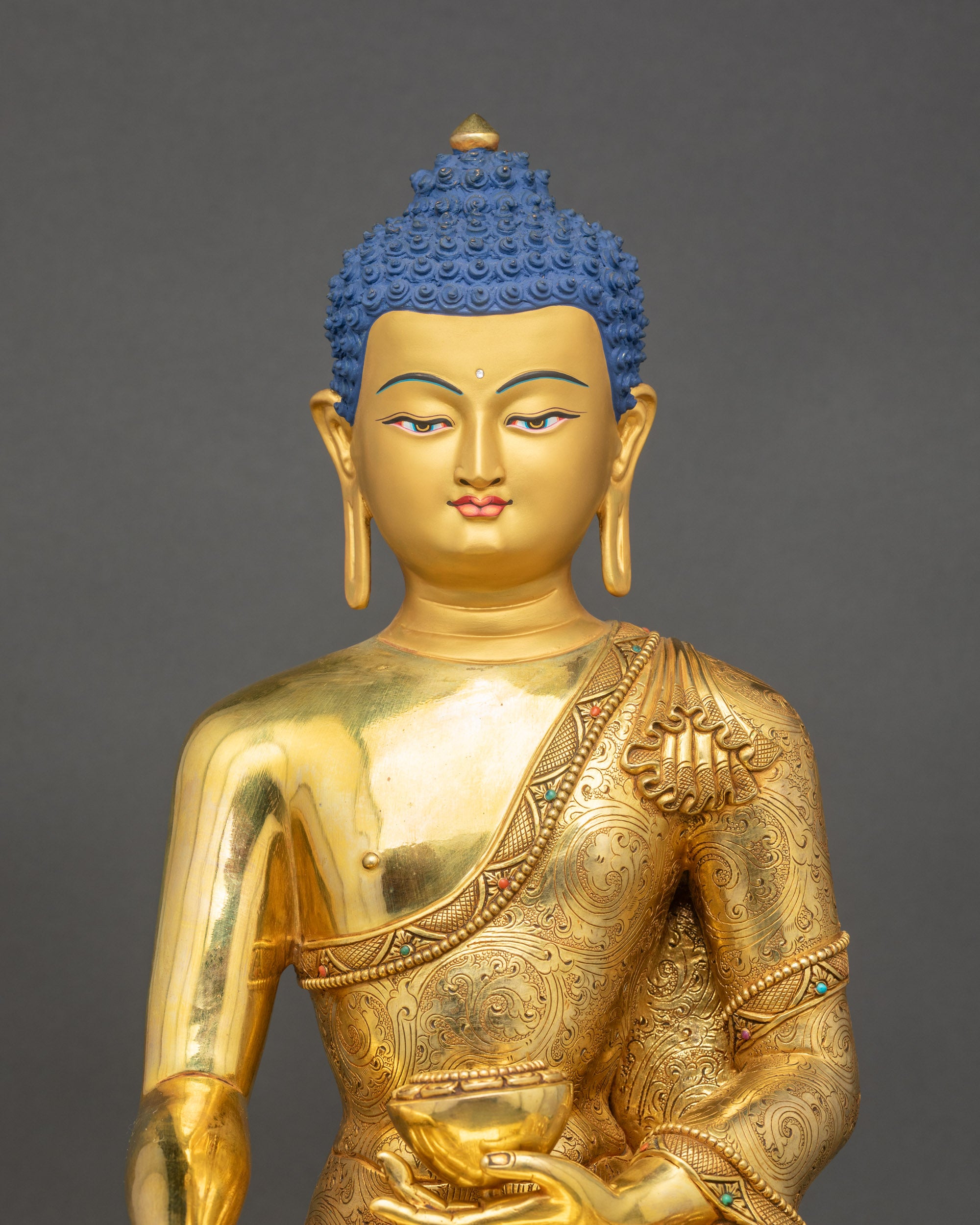 Close-up of handcrafted Shakyamuni Buddha statue showing gold fire-gilded details