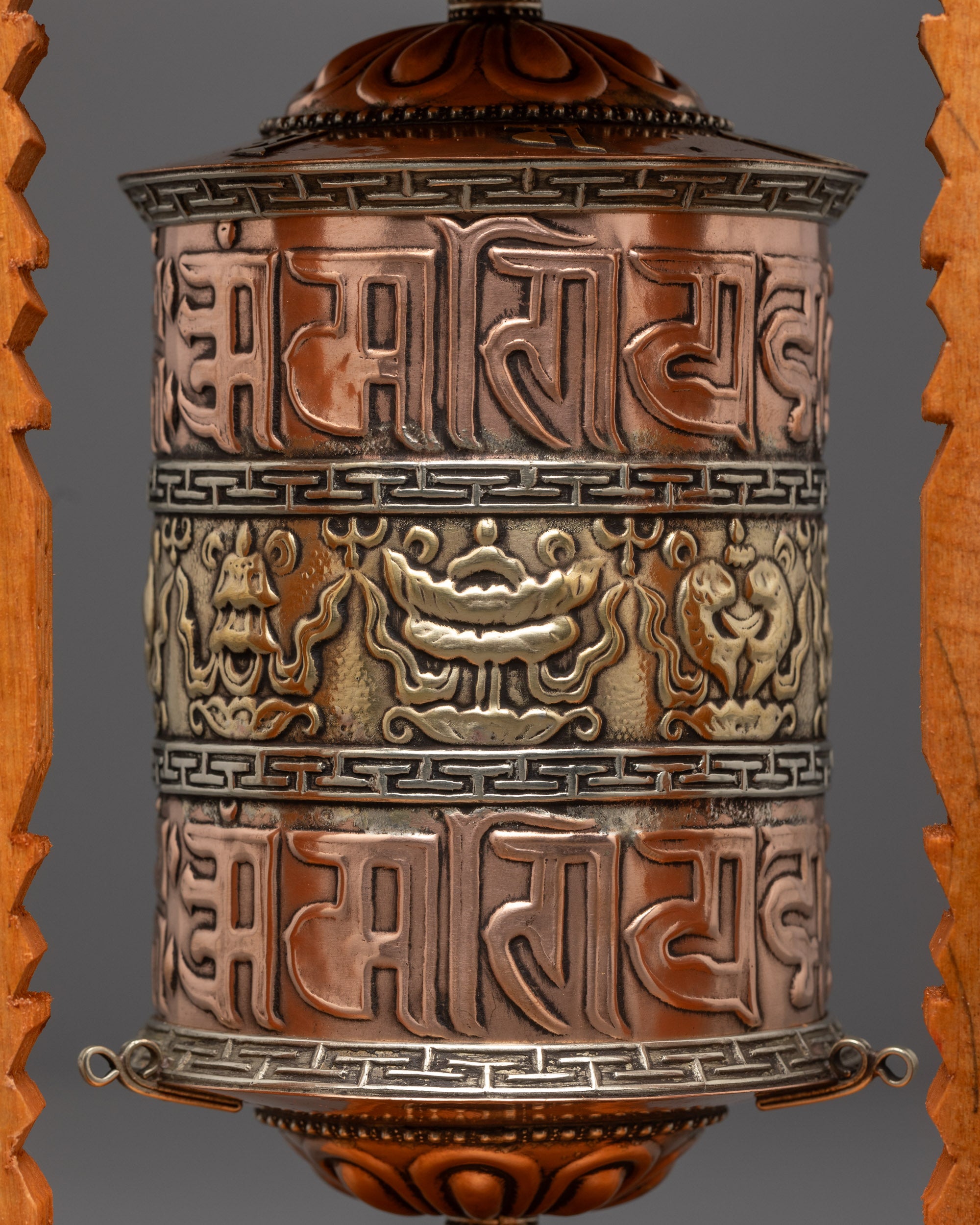 Close-up of sacred mantras and auspicious symbols on copper and bronze