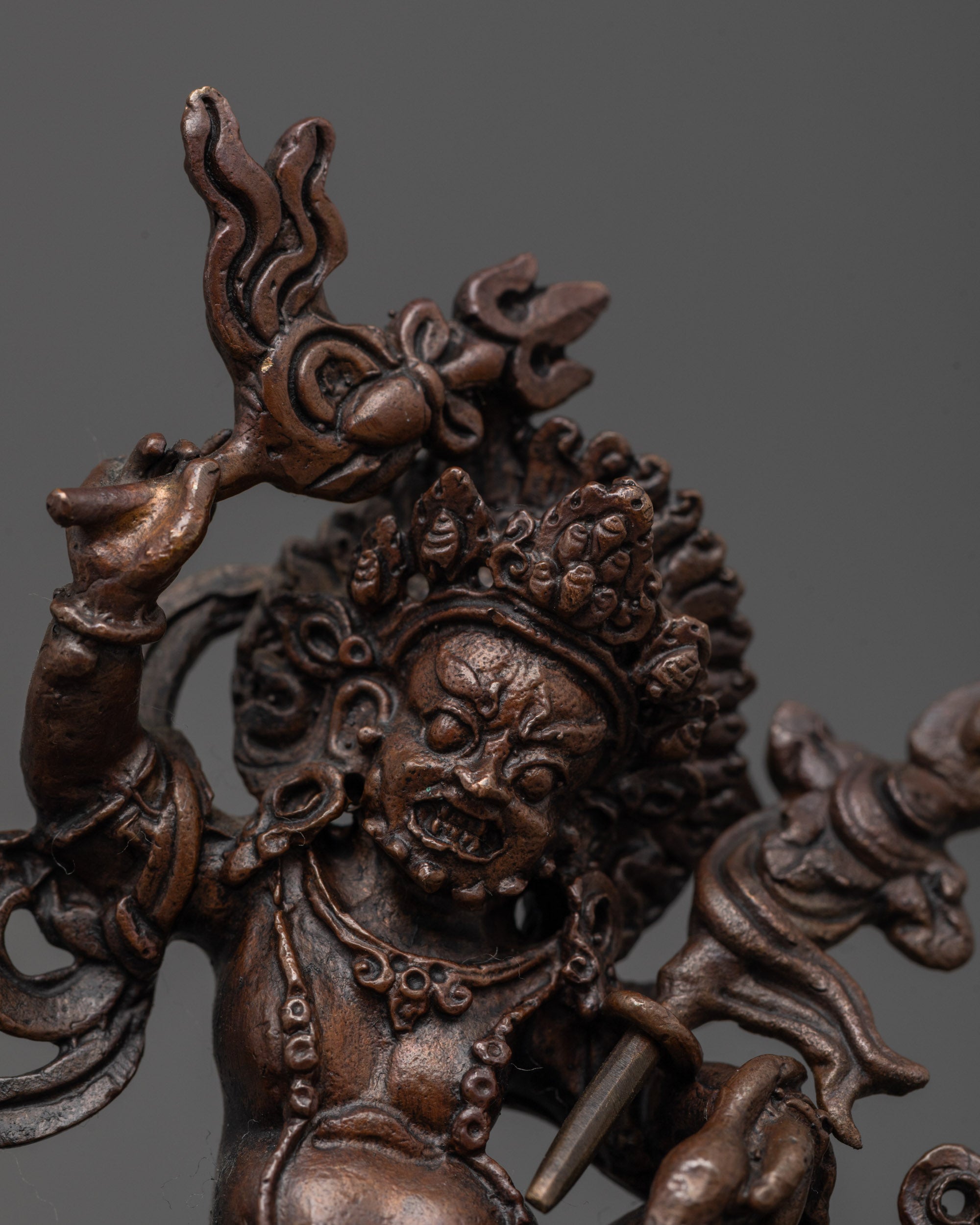 Close-up of oxidized copper face and crown of White Dzambhala Statue