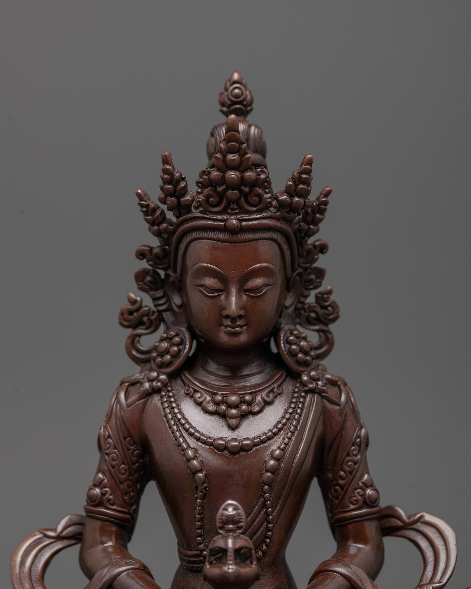Close-up of oxidized copper face and intricate carvings on Amitayus Statue