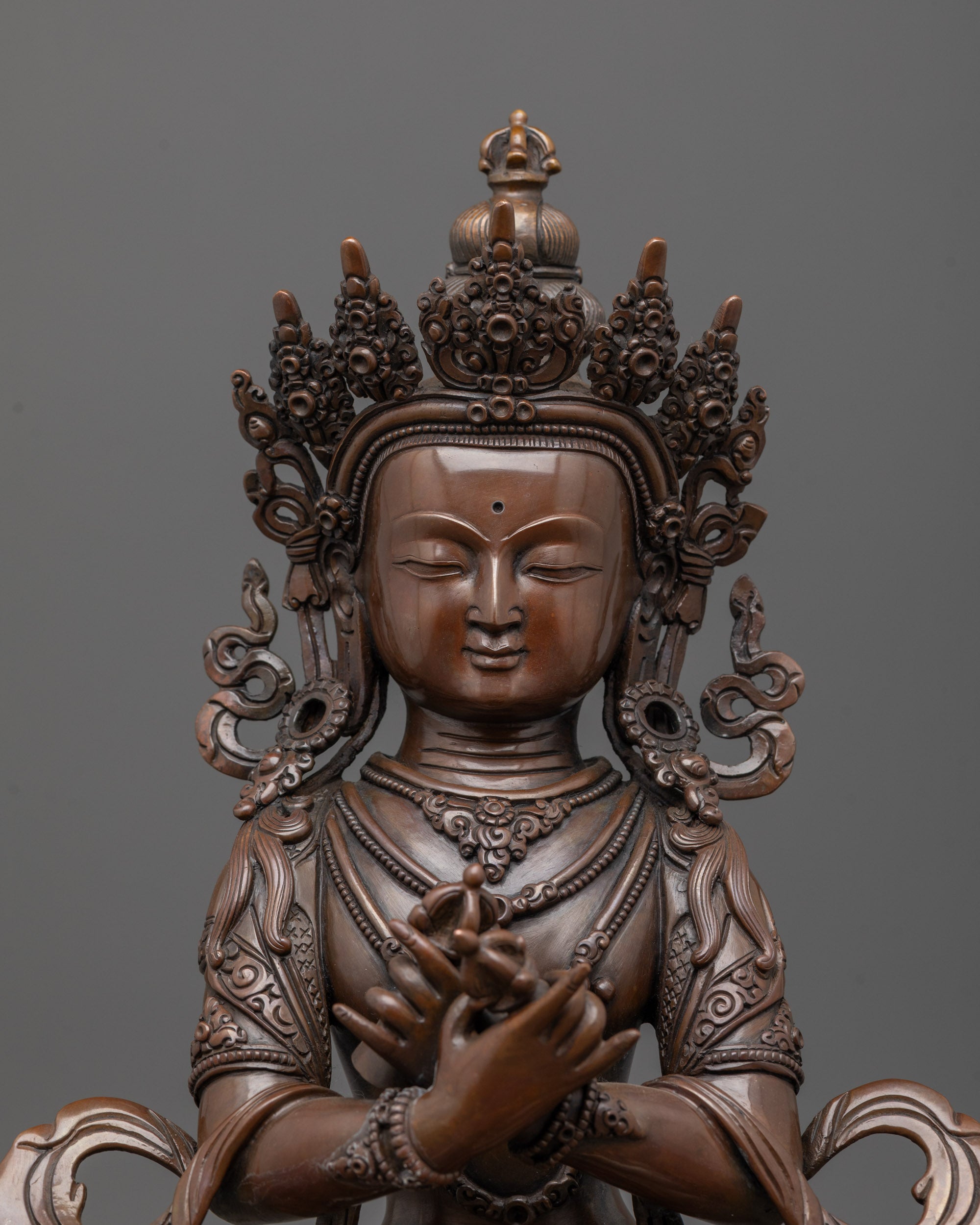 Close-up of oxidized copper face and vajrahumkara mudra on Himalayan Vajradhara statue