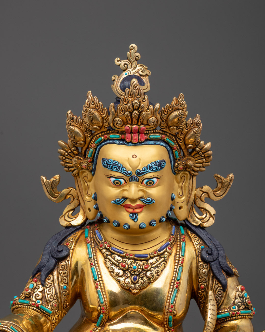 Close-up of the 24K gold-coated face of Dzambhala, showcasing intricate detailing and divine serenity, handcrafted by Nepalese artisans.