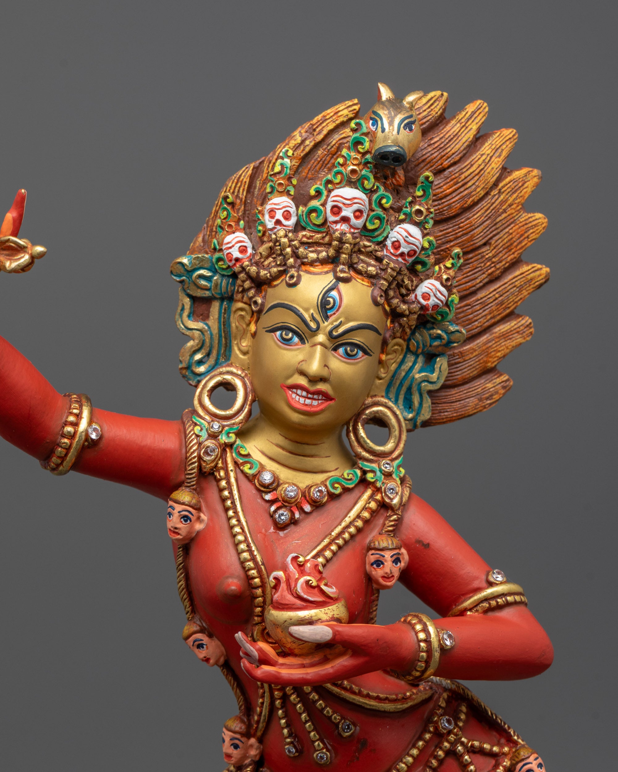 Close-up of vibrant red Dorje Phagmo Statue with fierce halo and intricate copper