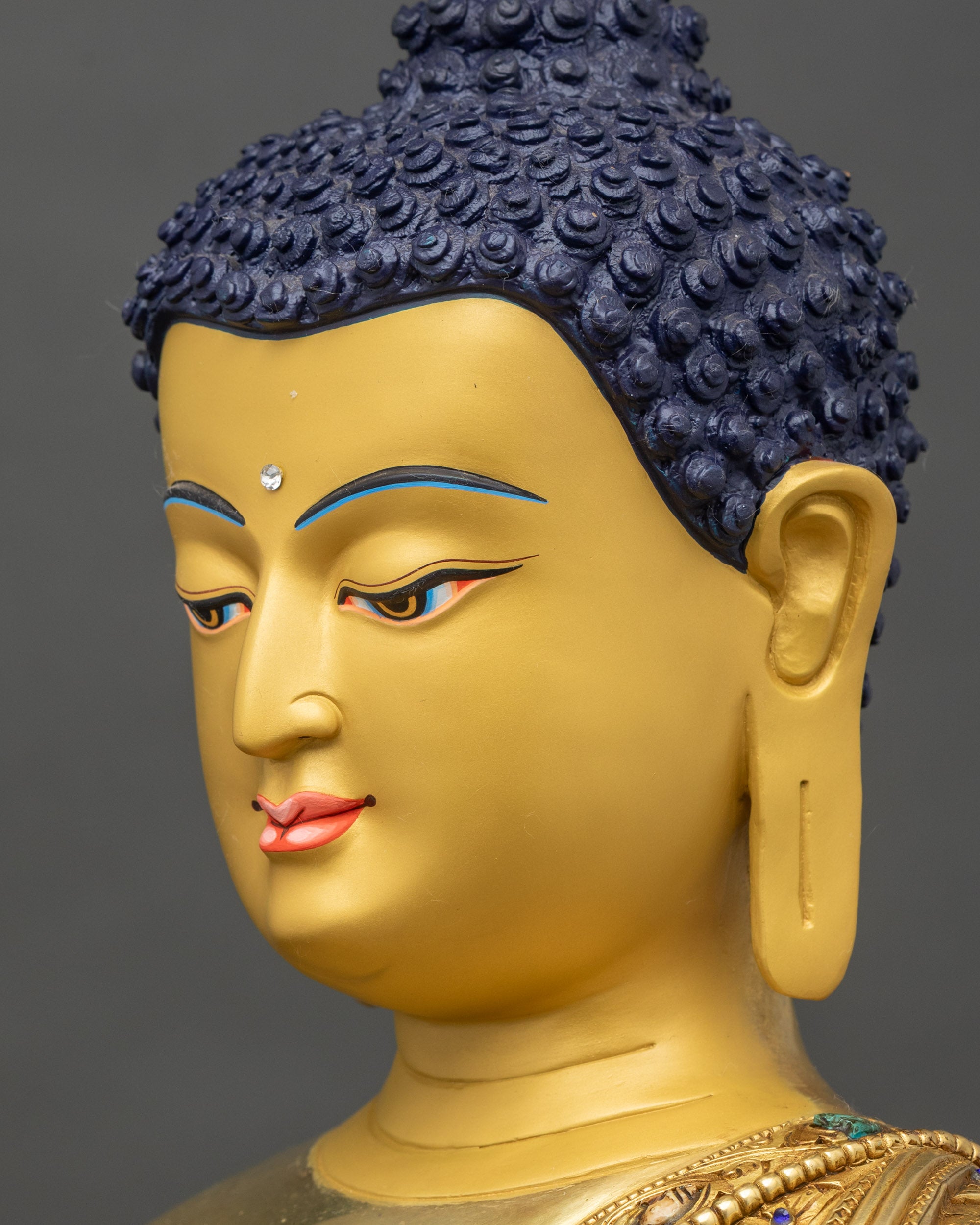 Close-up side of Buddha face, semi-precious stones and hand-painted gold finish