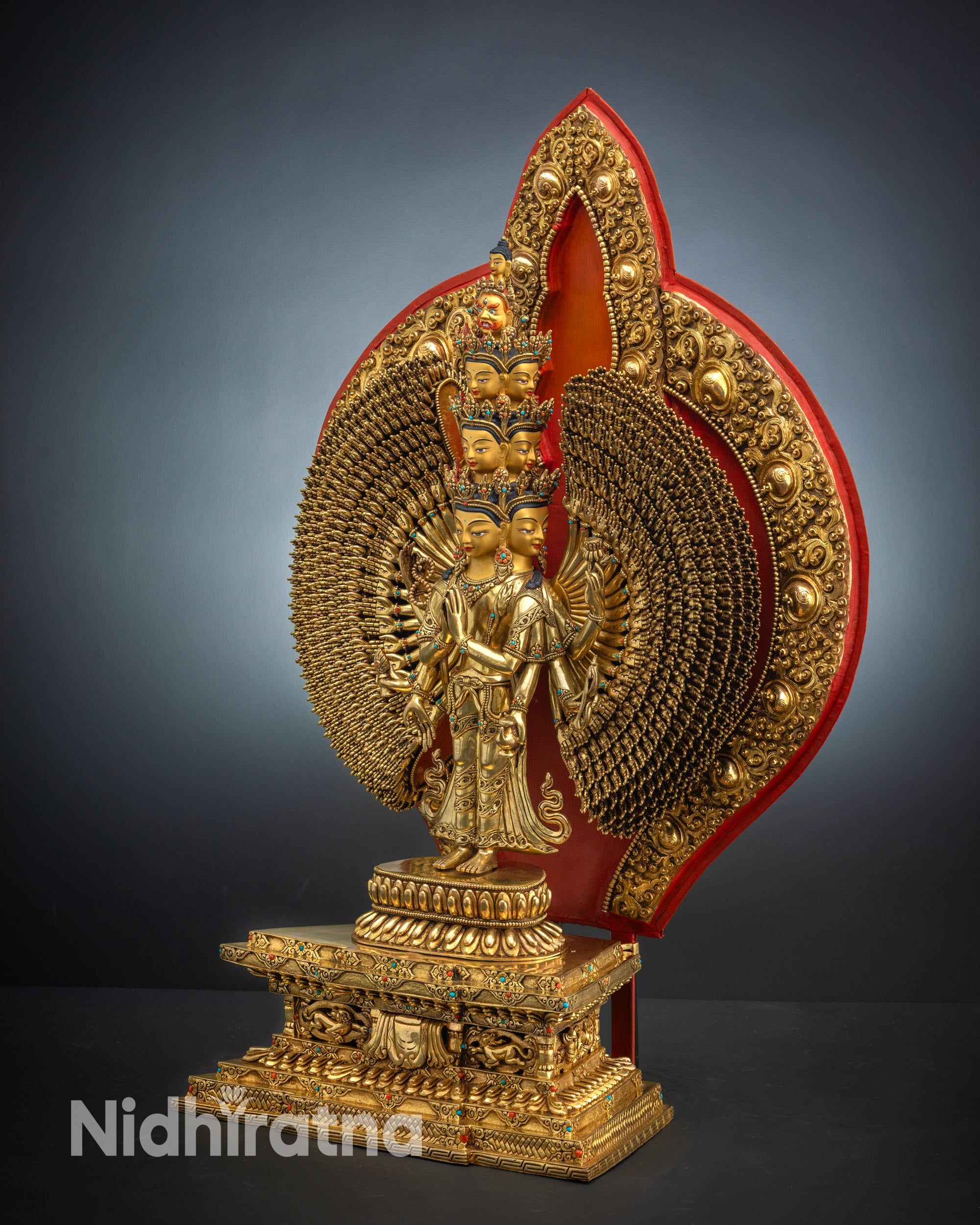 Close-up upper side view of 1000 Armed Chenrezig statue with gold-gilded face and jeweled crown