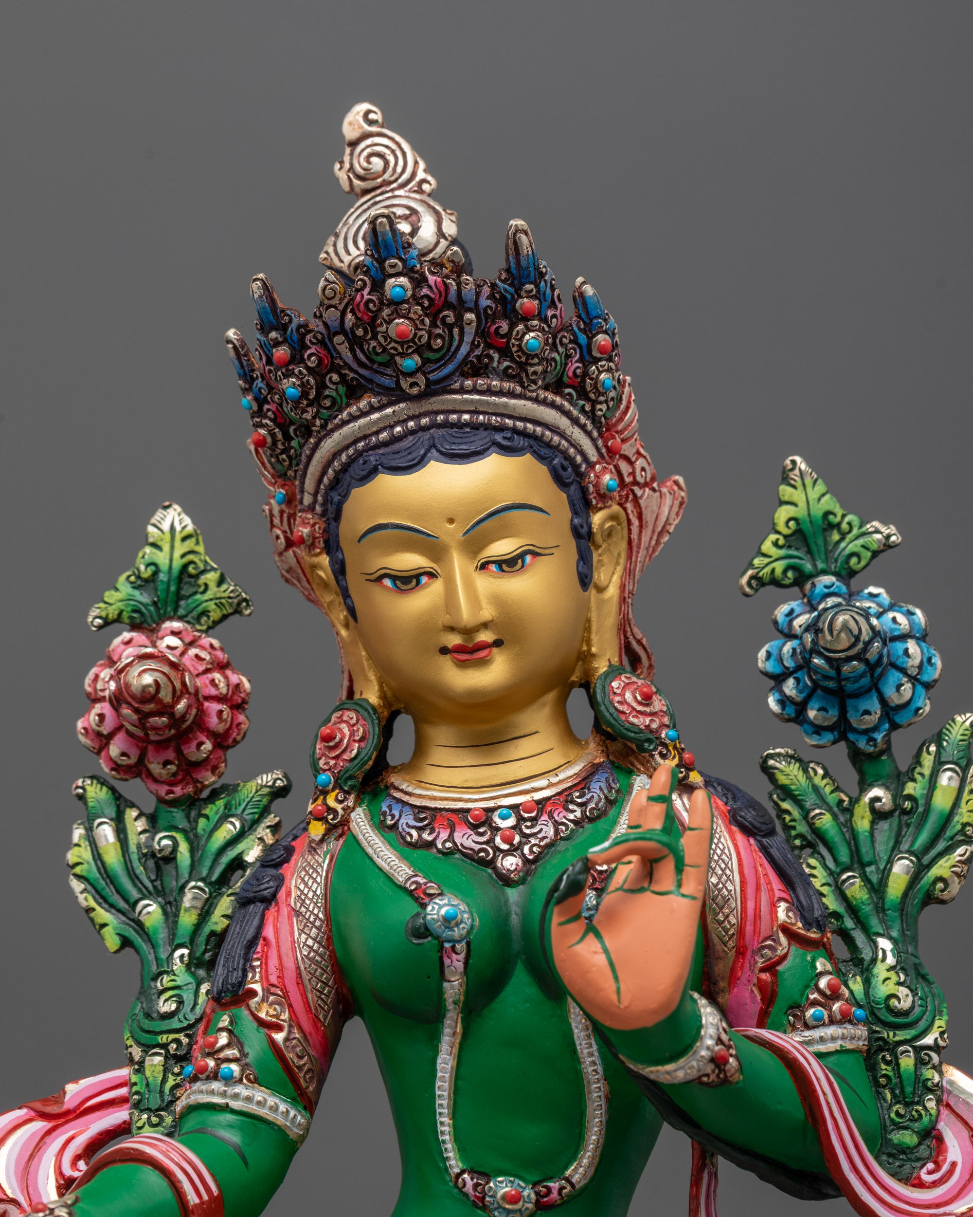 Close-up view of Green Tara face with serene expression adorned with semi-precious stones