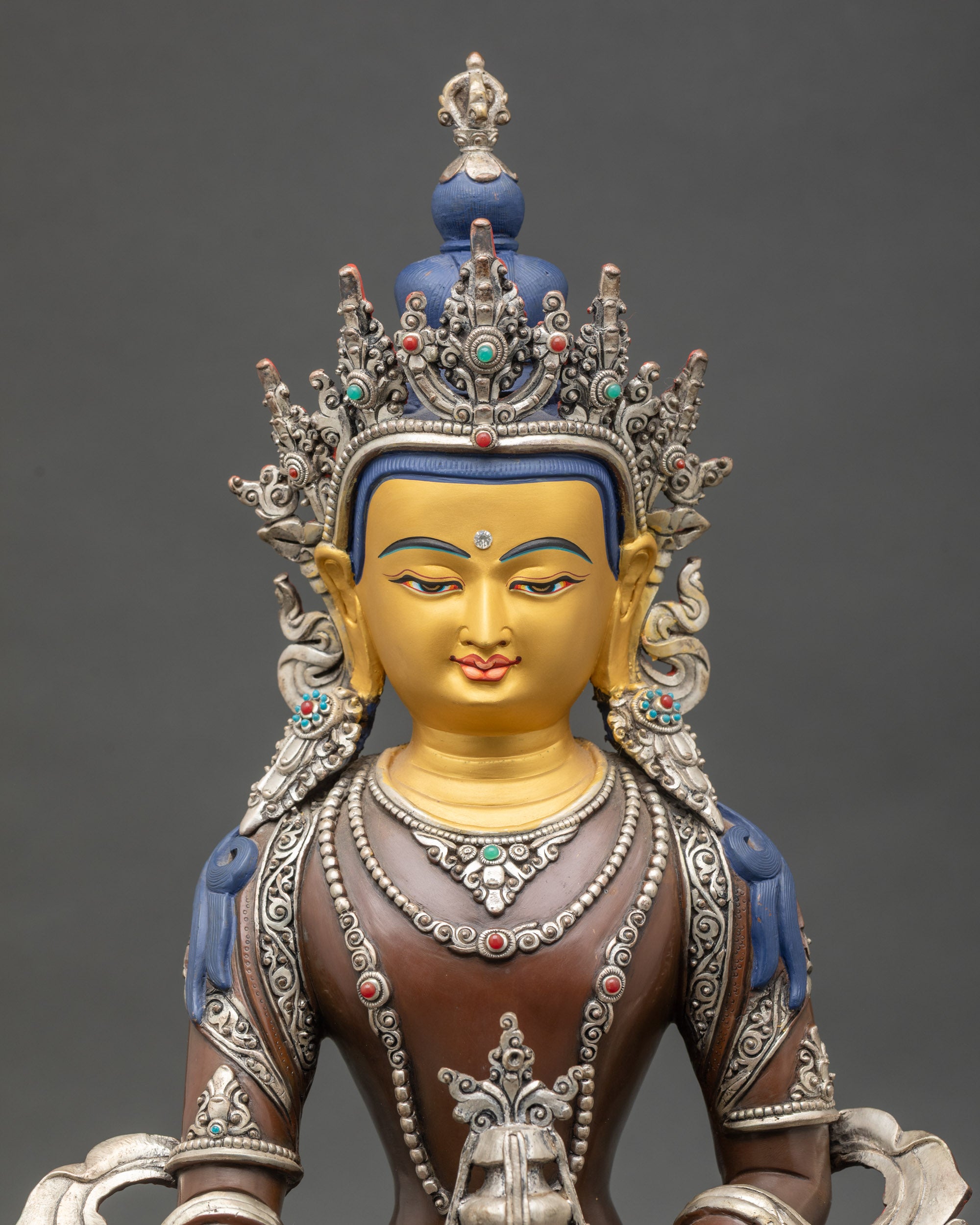 Close-up view of Kshitigarbha statue showing copper and silver-plated details