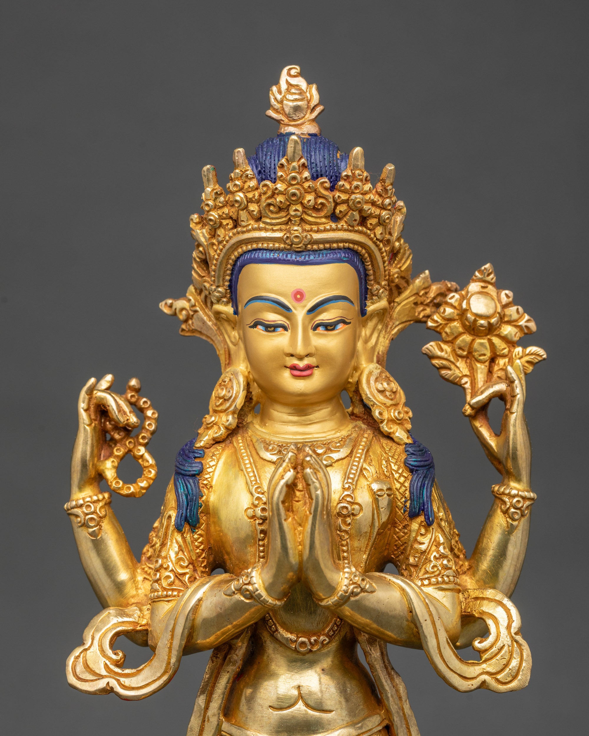 Close up Chenrezig gold-gilded face with five-jeweled crown and serene expression