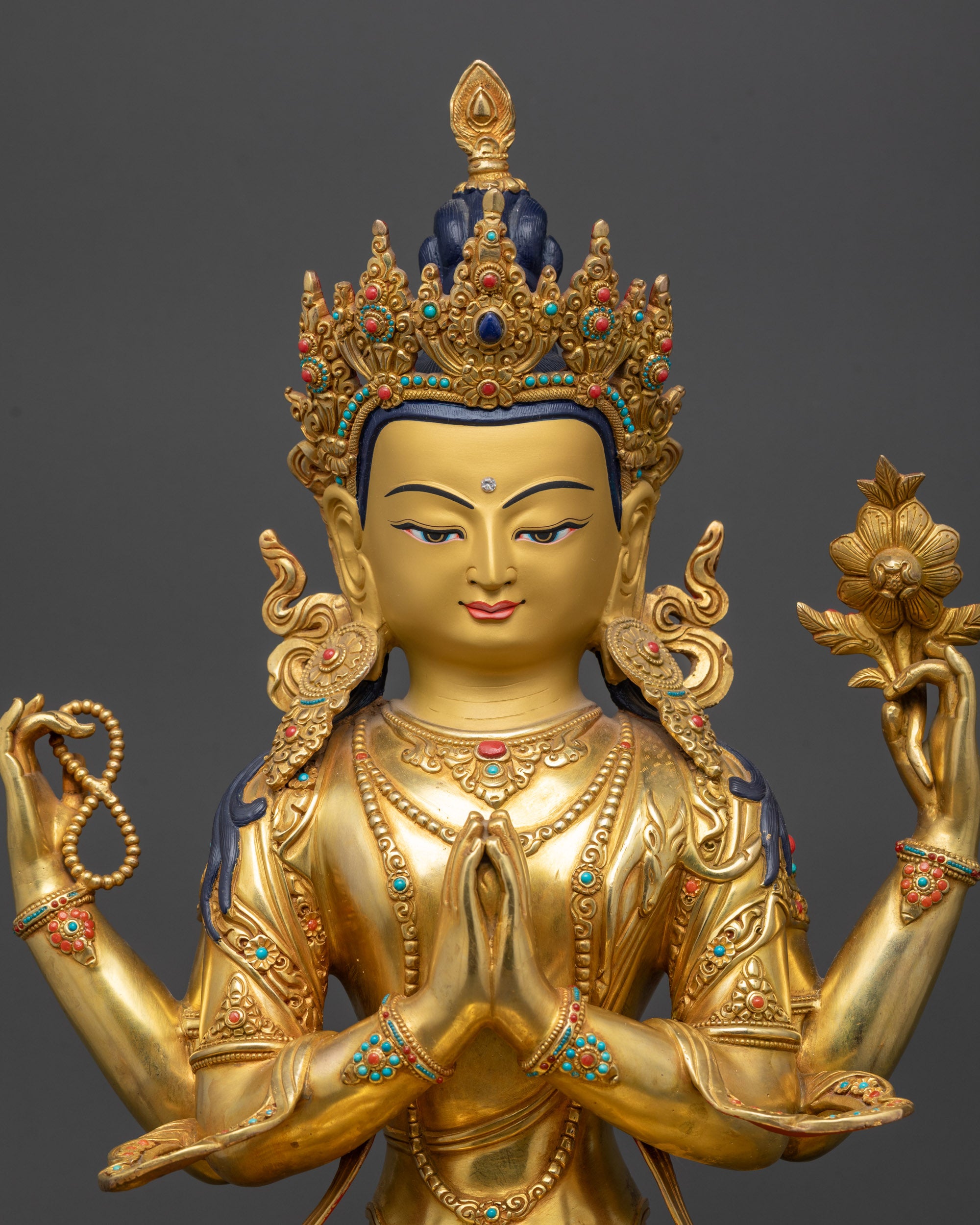 Close up Chenrezig statue highlighting crystal rosary and lotus flower in hands