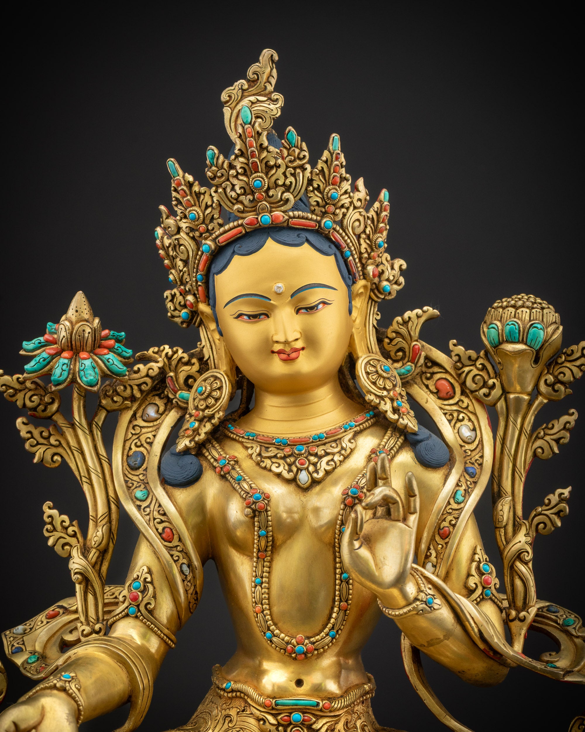 Close up Green Tara Statue showing gold-gilded face, jeweled crown, and flowing robes