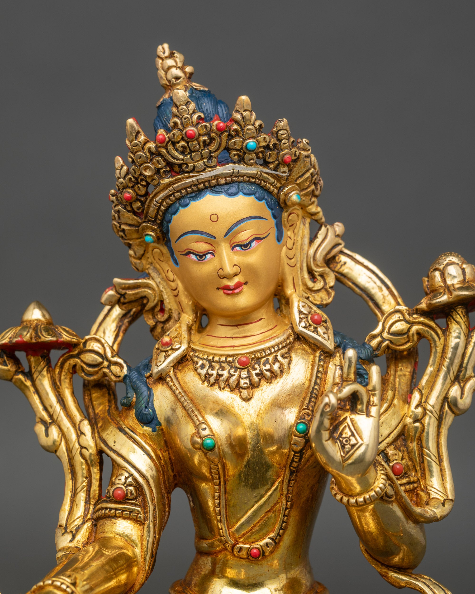 Close up Green Tara face gold-painted with five-jeweled crown, handmade Nepal Buddhist art