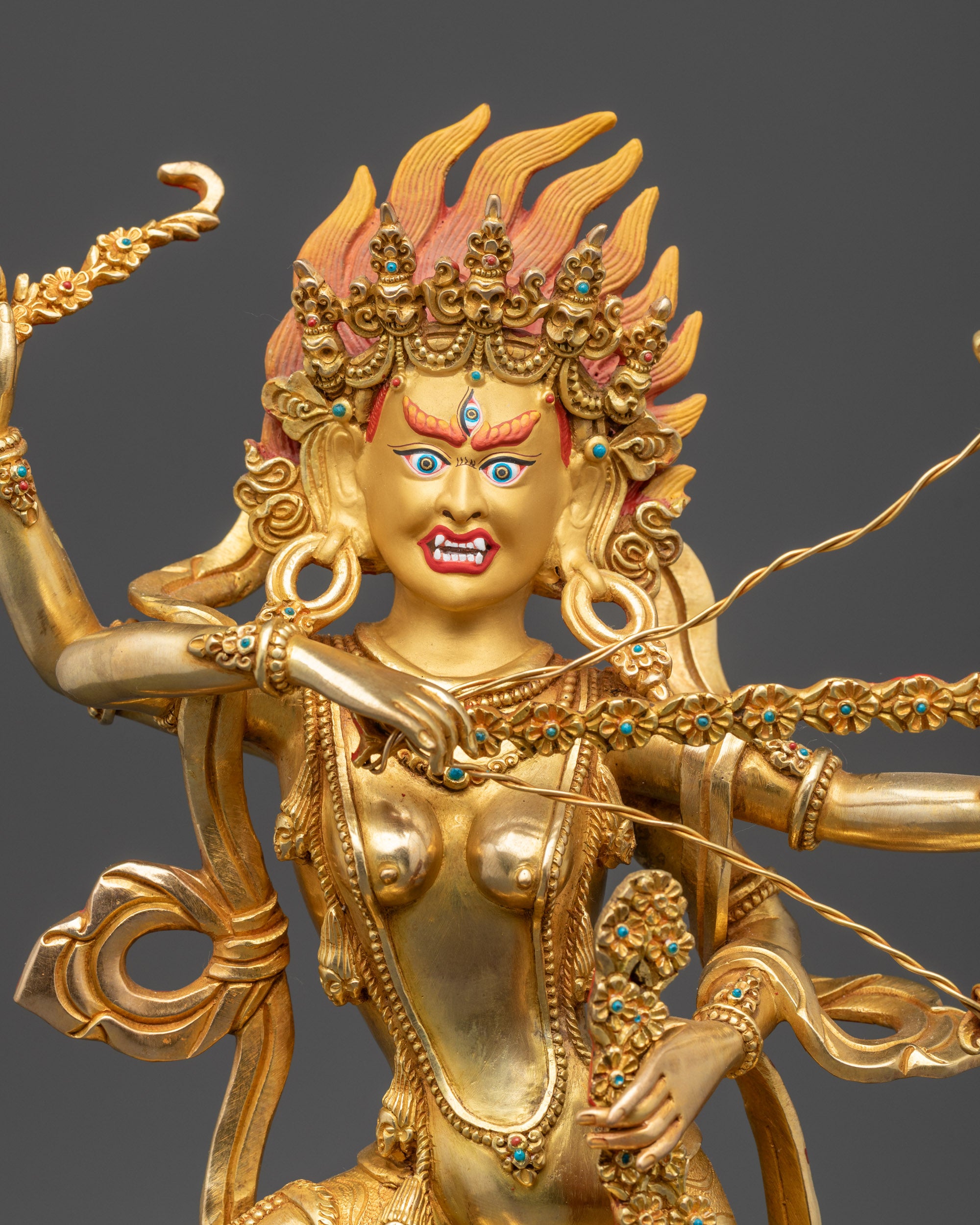 Close up Kurukulla statue showing third eye, bow and arrows, hook, and noose in detail