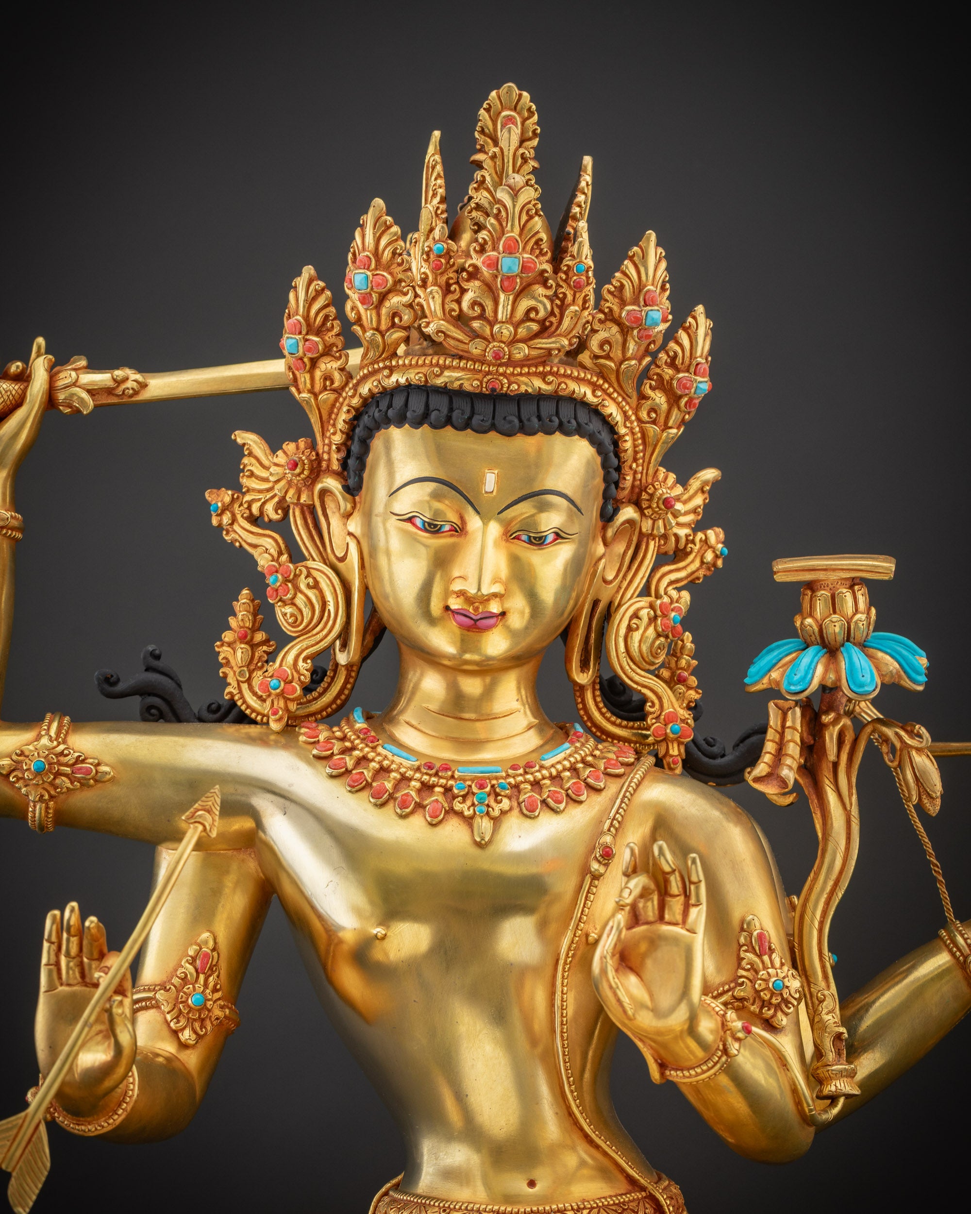 Close up Maha Manjushri Statue glowing gold gilded face with radiant copper base and fine details