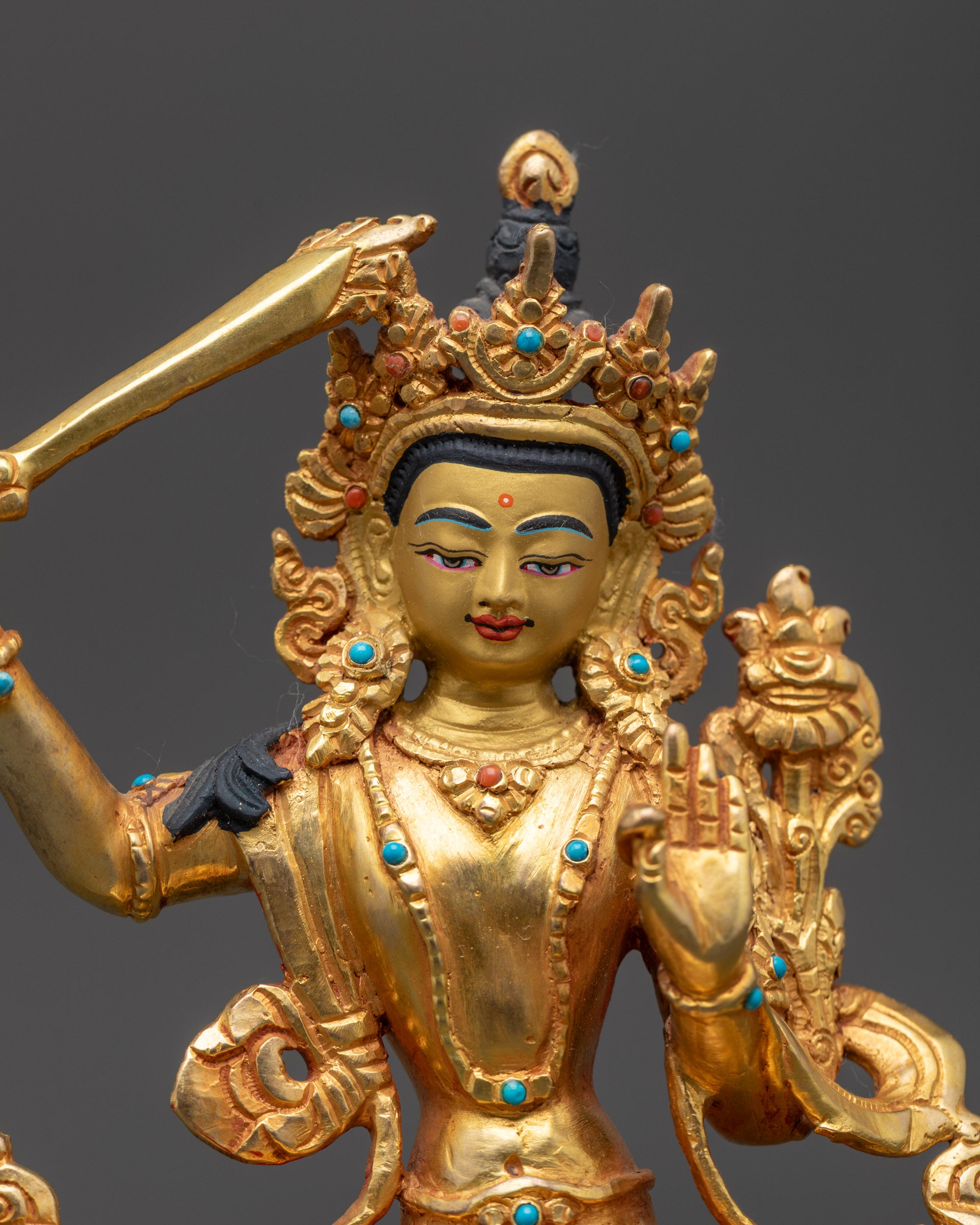 Close up Manjushri Sculpture showing detailed crown, armlets, and flowing robes