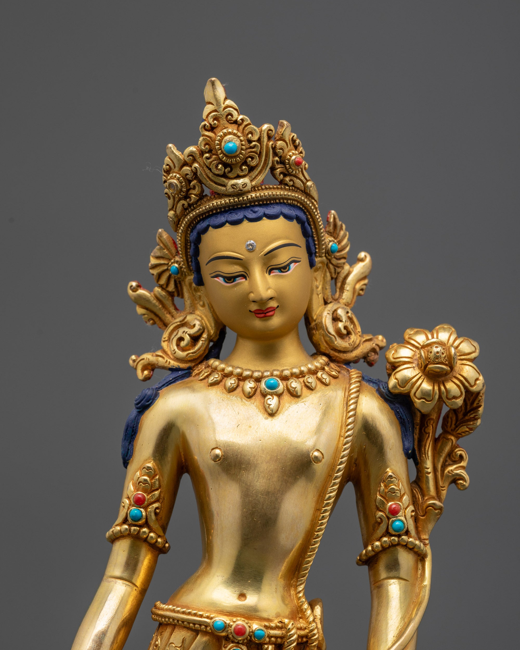 Close up Padmapani statue showing utpala flower and semi-precious stone garment