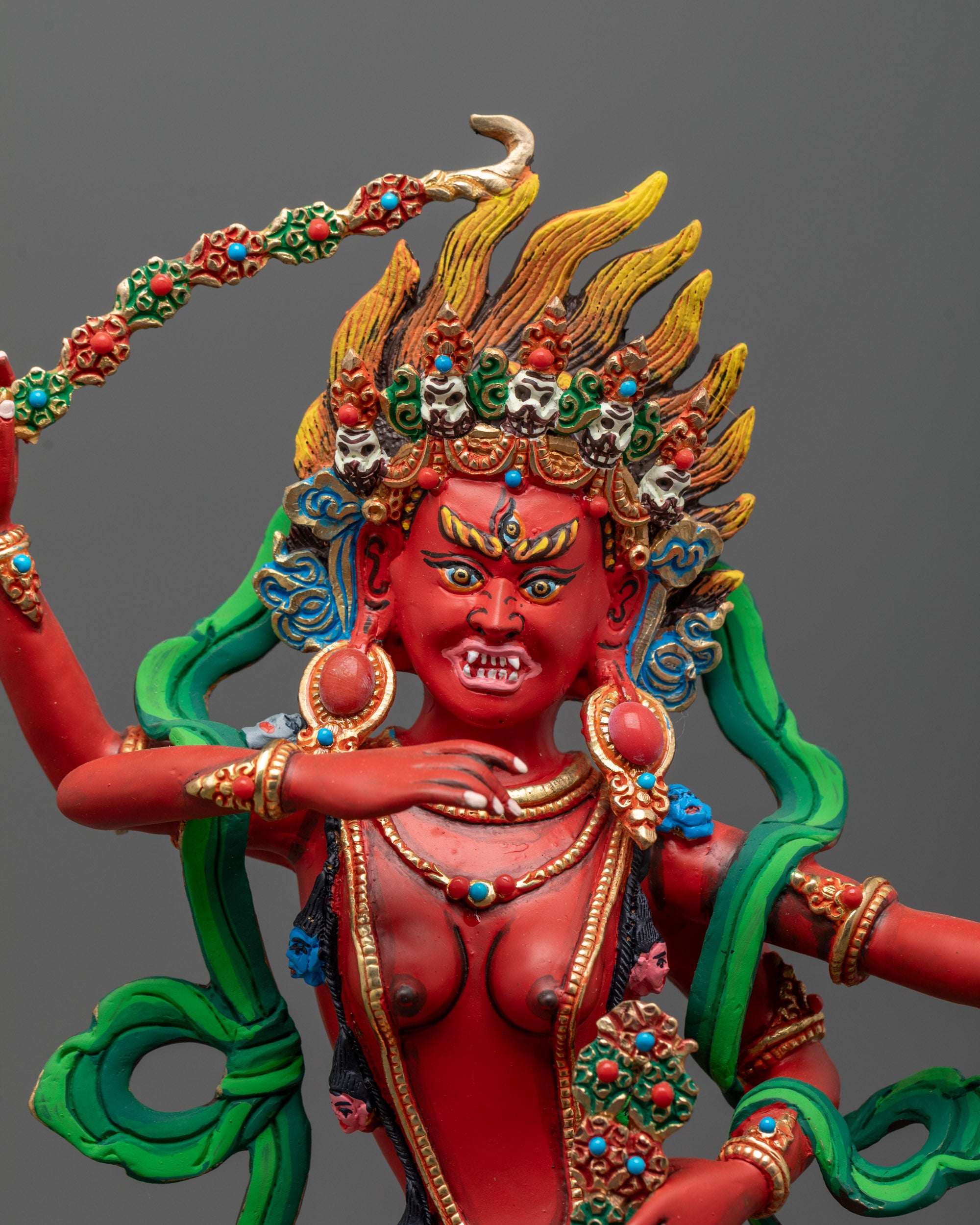 Close up Red-painted Kurukulla Sculpture adorned with semi-precious stones