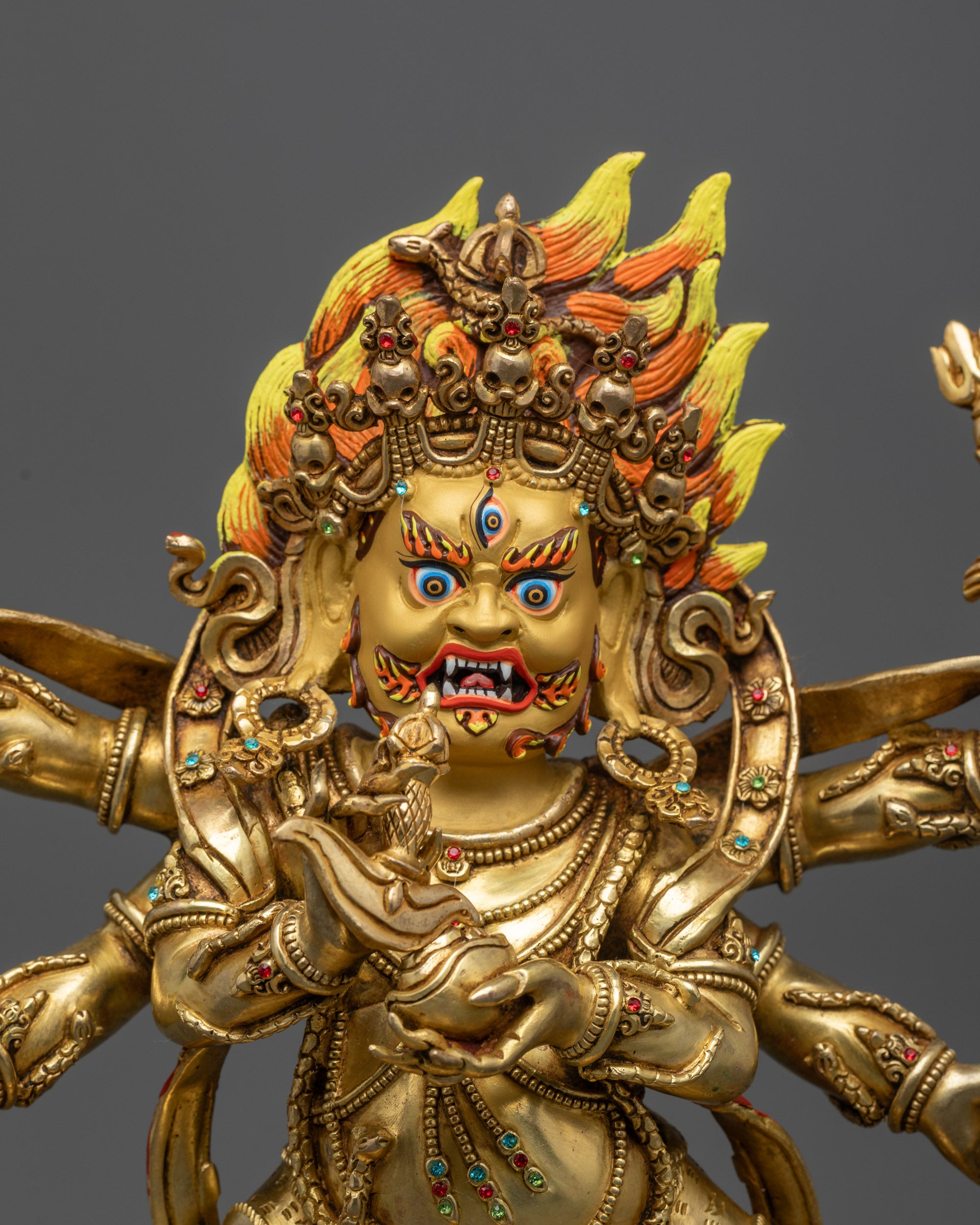 Close up Six-Armed Mahakala Statue showing gold fire gilded body and semi-precious stones