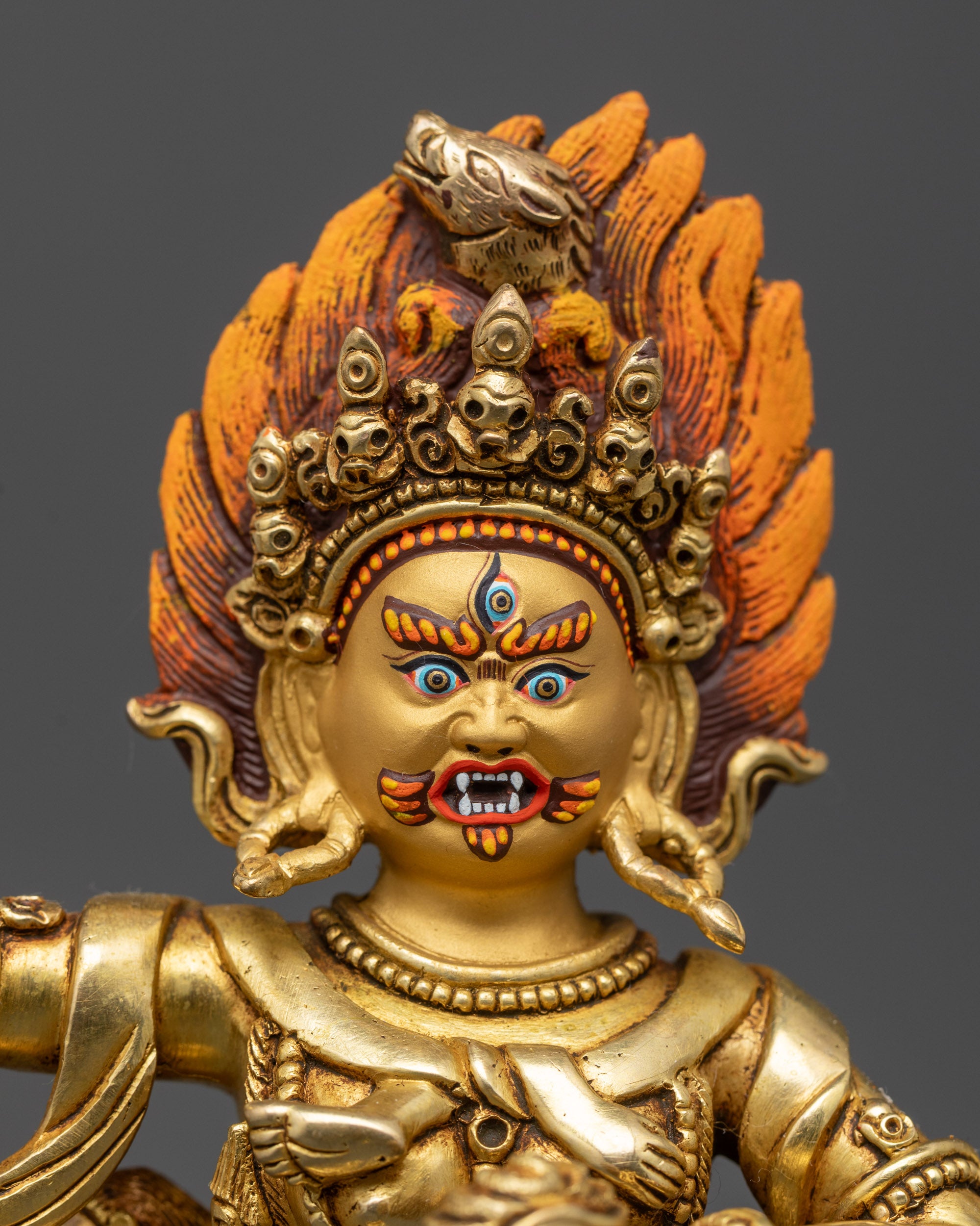 Close up Troma Nagmo face with third eye, five-skull crown, and gold-fire gilded details