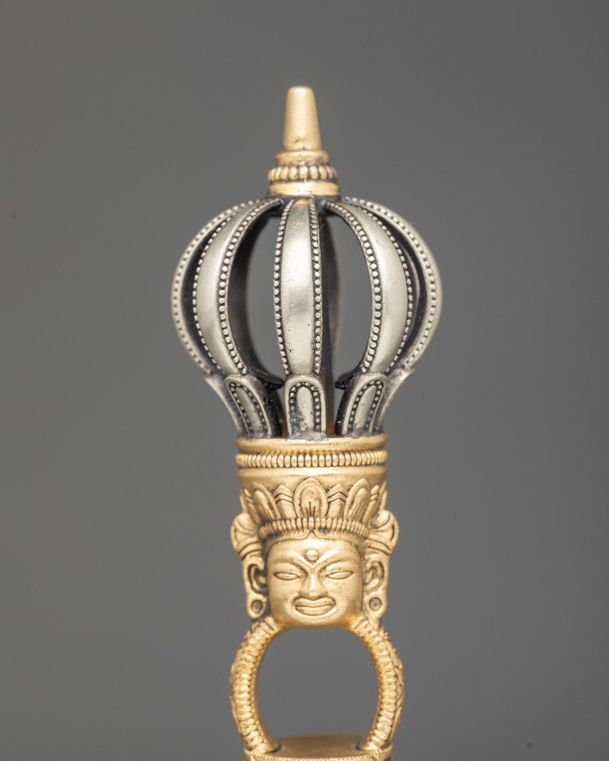 Close up copper handle bell with deity carving Himalayan ritual instrument