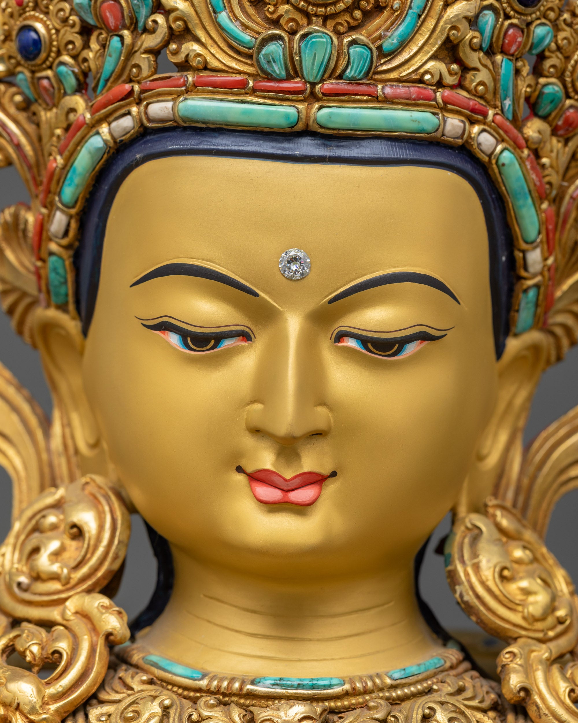 Close up face of Manjushri statue showing calm expression and jeweled crown
