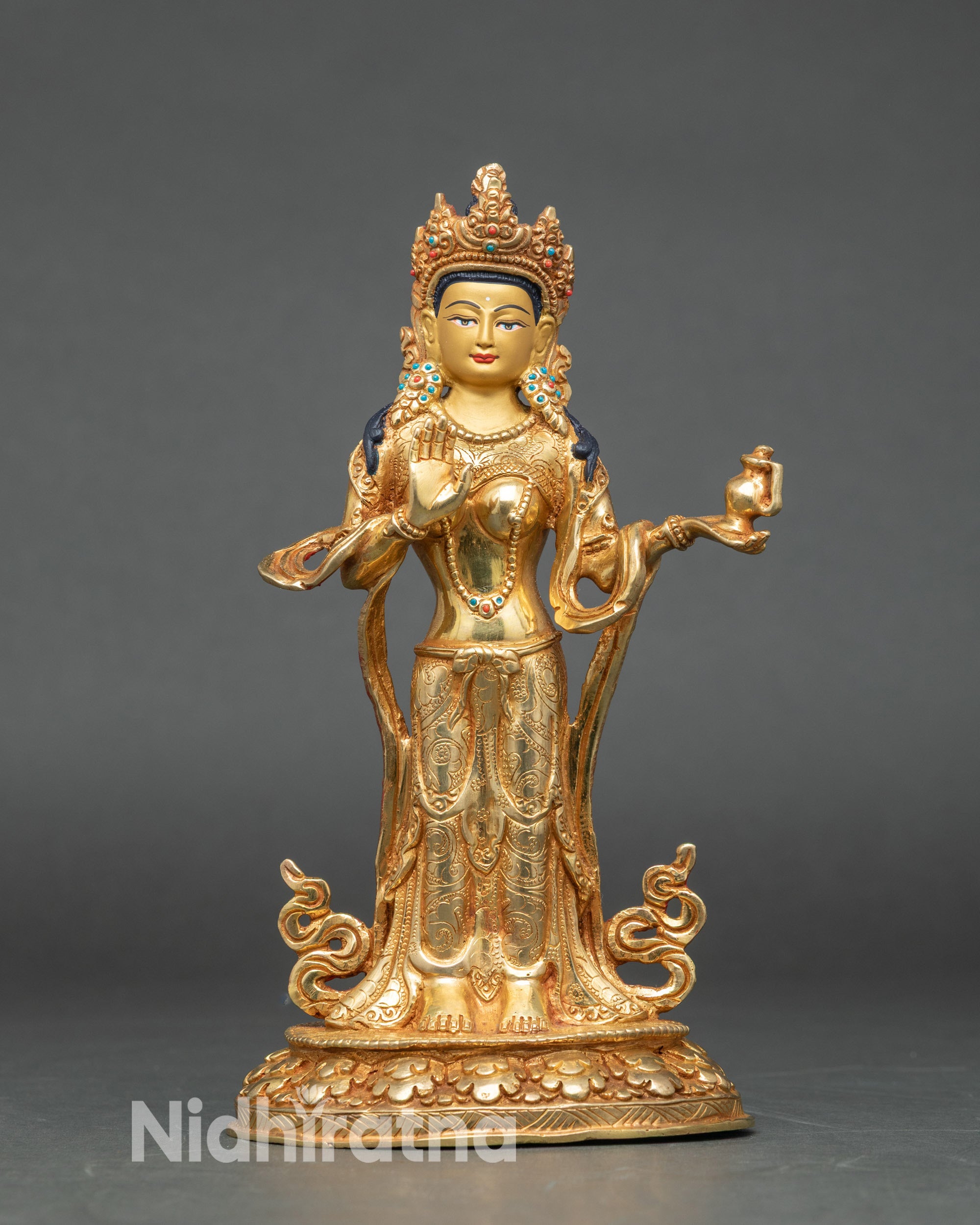 Close up gold-painted face Abhaya Mudra Tibetan Himalayan sacred sculpture