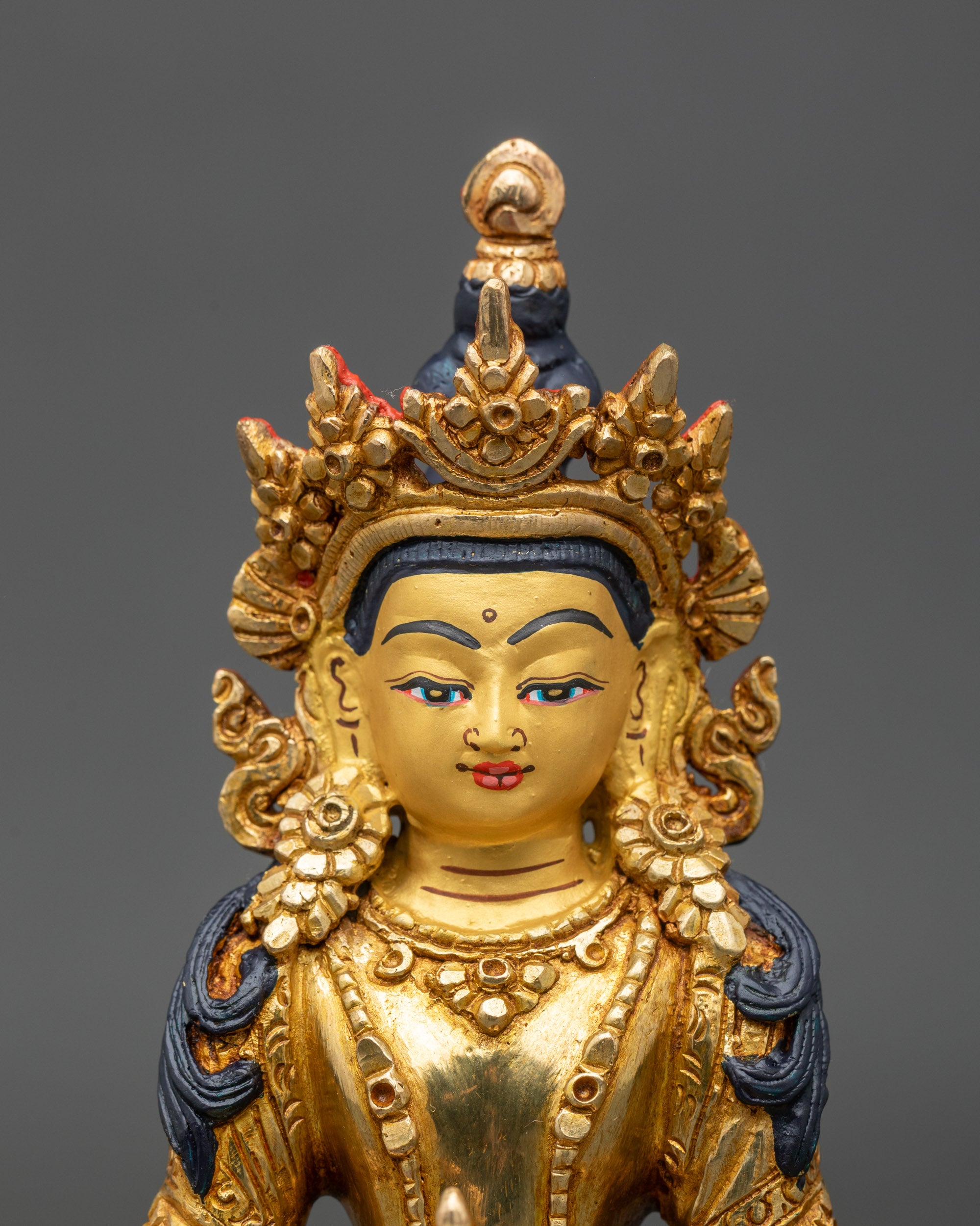 Close up gold-painted face Bodhisattva Amitayus statue handmade Newari craftsmanship