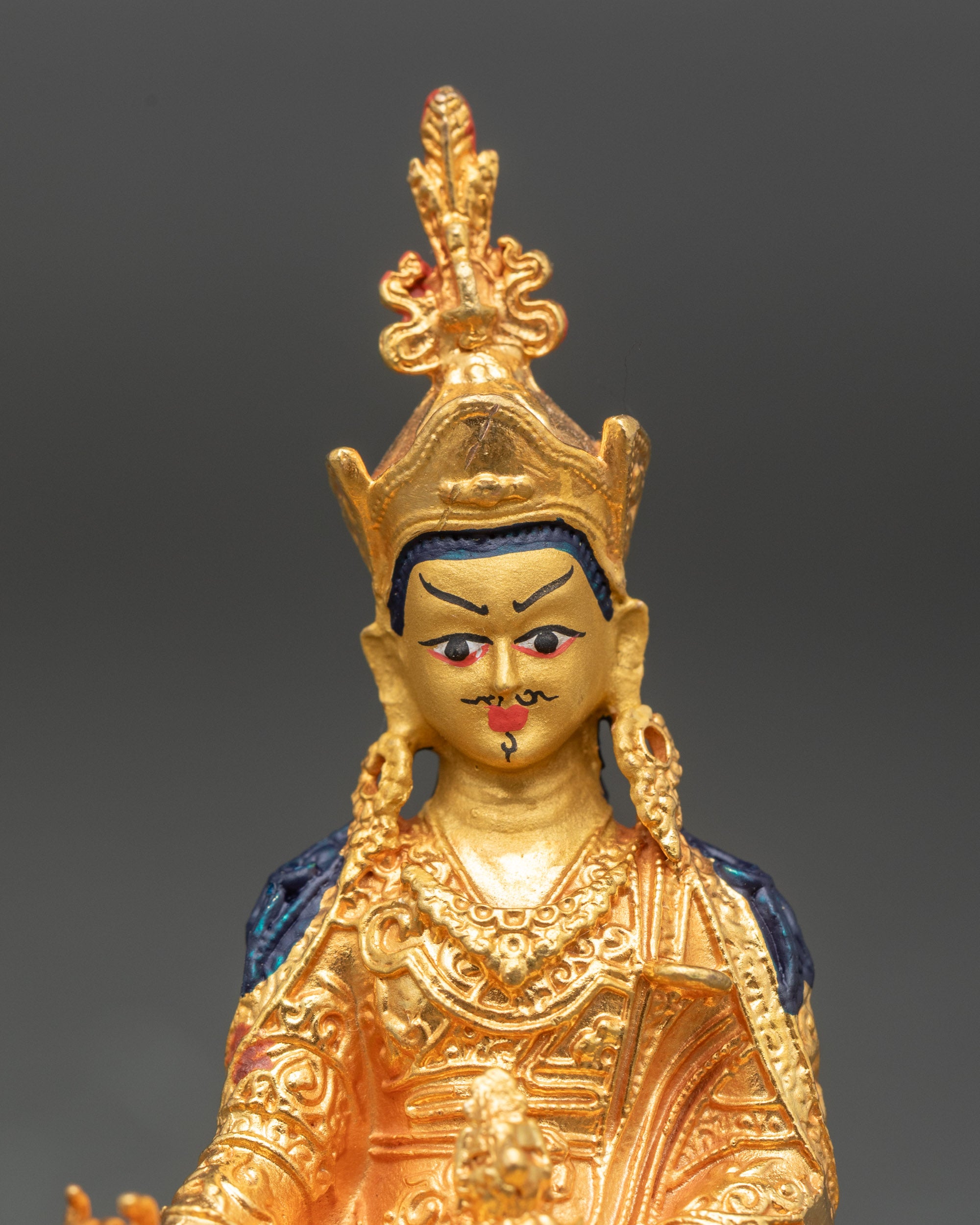 Close up gold-painted face vajra and kapala Nepalese Buddhist sculpture