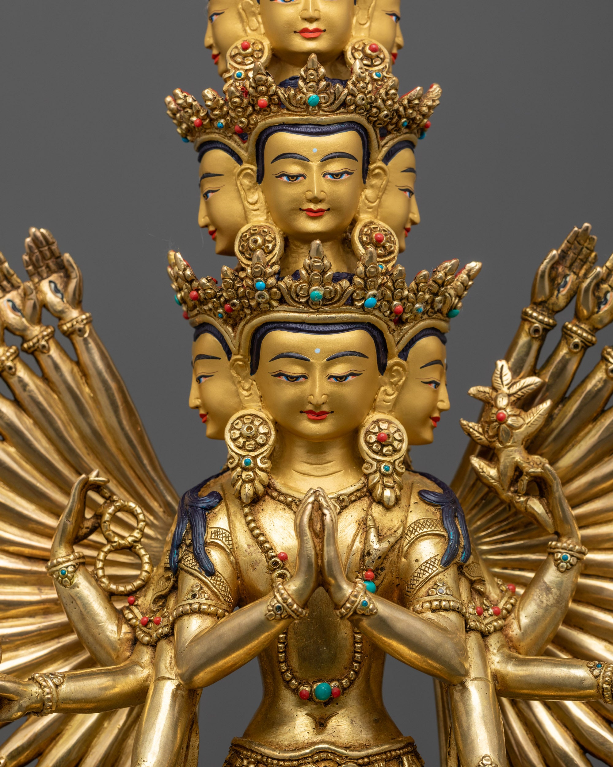 Close up of 1000-Armed Chenrezig face with serene expression and gold-gilded features