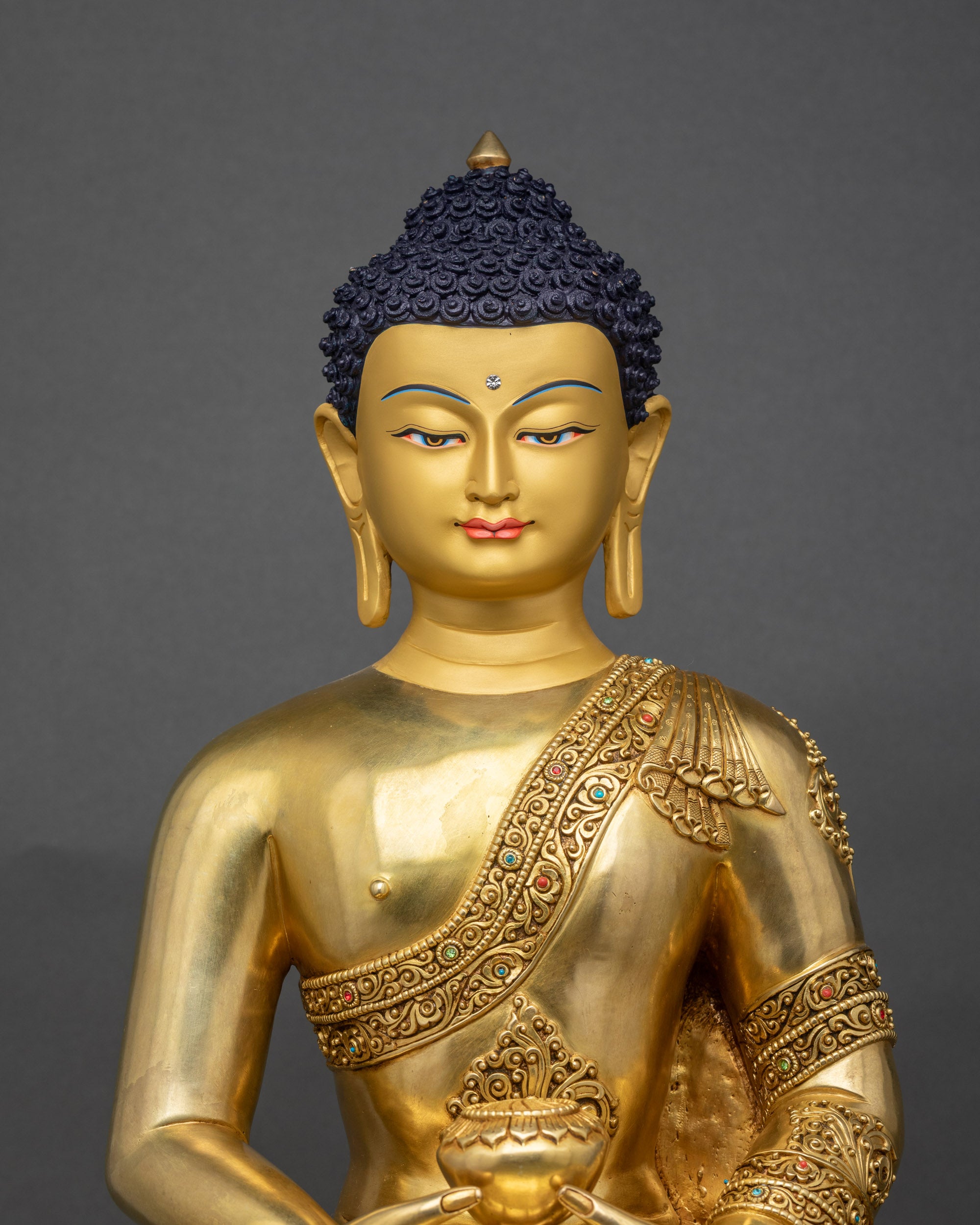 Close up of Amitabha Buddha statue showing robe carvings and gold fire gilding