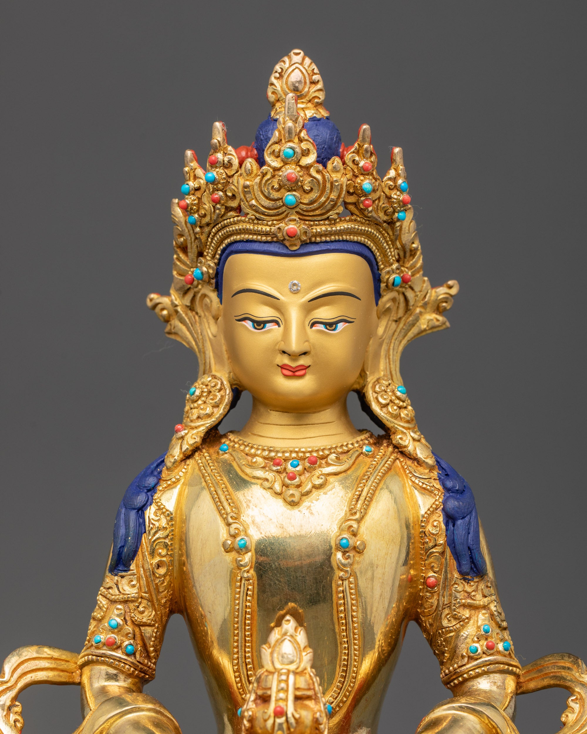Close up of Amitayus Buddha gold-gilded face and intricate crown with semi-precious stones