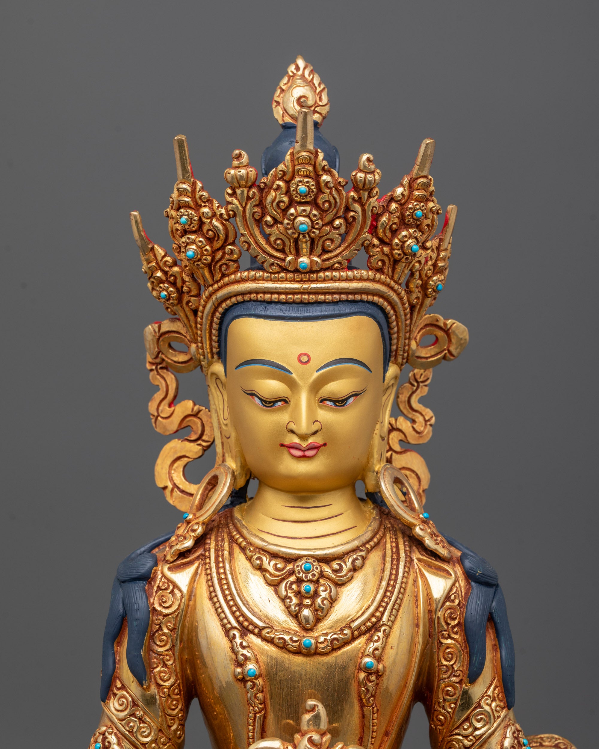 Close up of Amitayus Statue’s 24K gold face and semi-precious stones on jeweled crown
