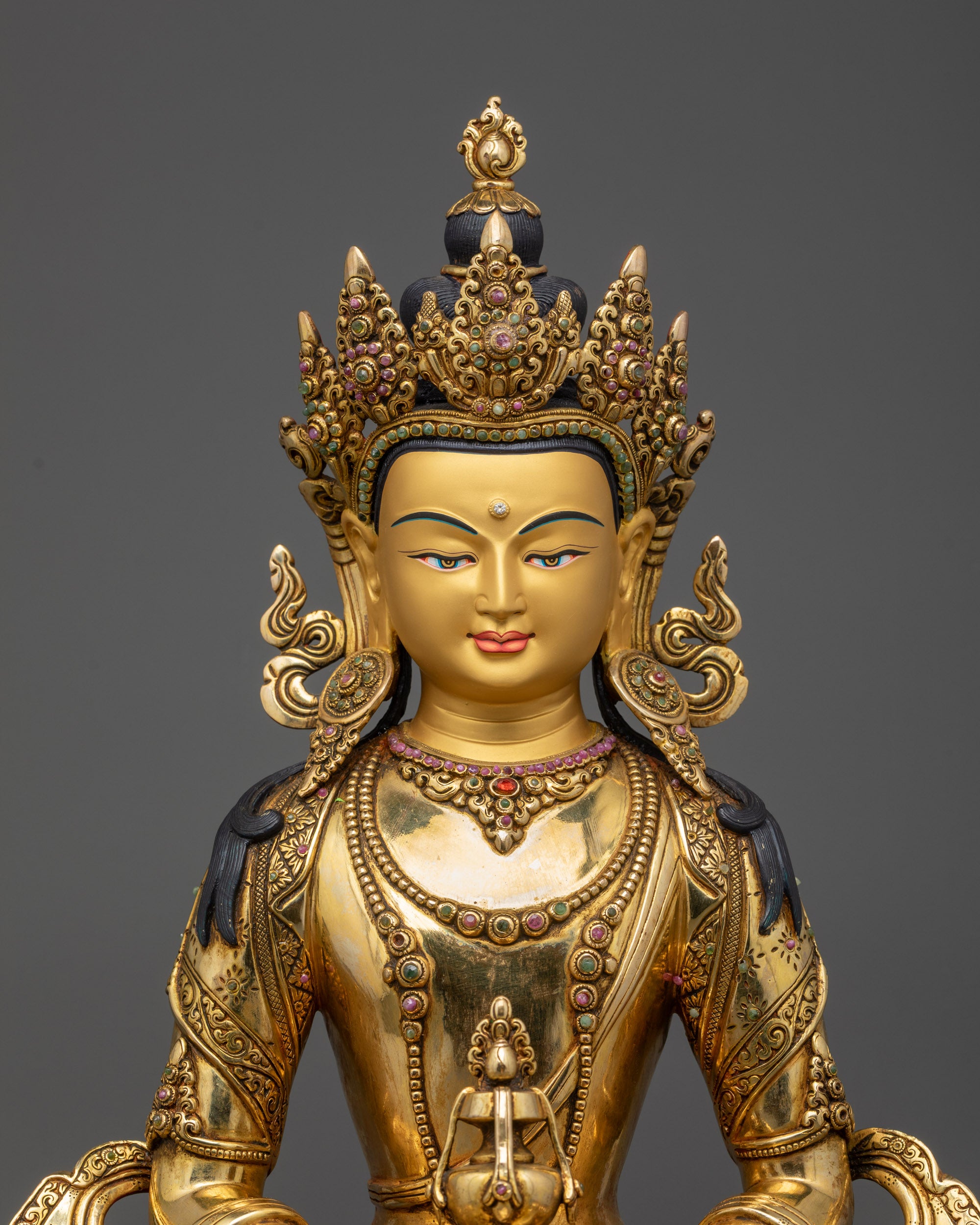 Close up of Amitayus Statue showing serene gold-gilded face and floral halo