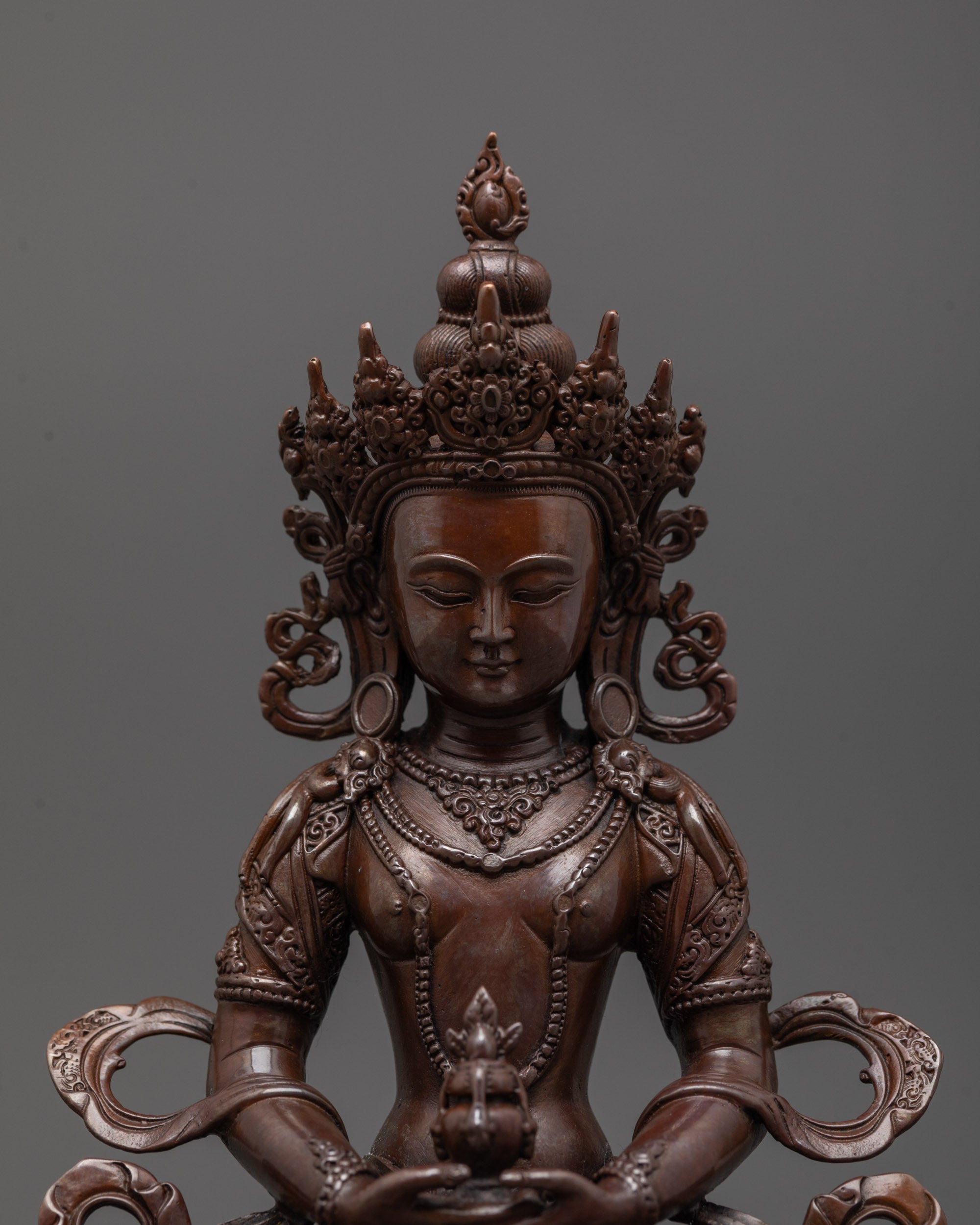 Close-up of Amitayus statue highlighting detailed machine-crafted features and rich oxidized tone