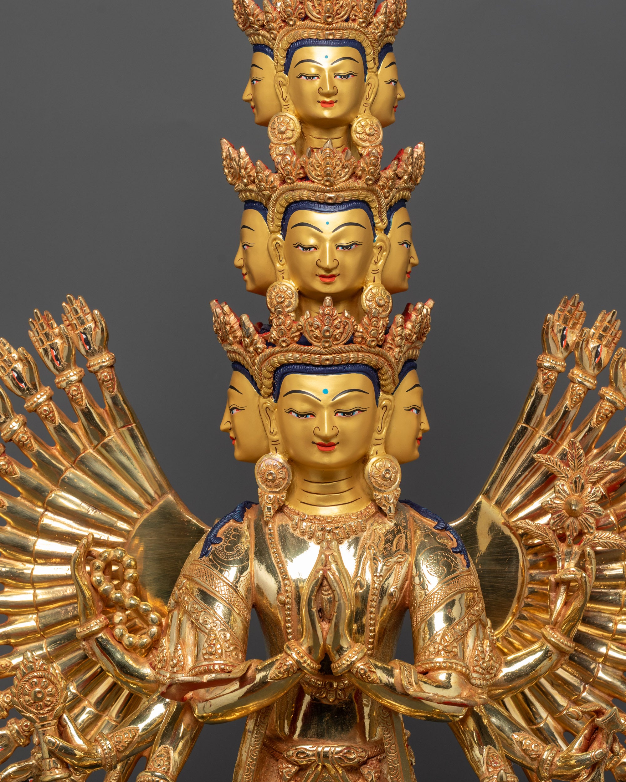 Close up of Avalokiteshvara statue showing eyes on each palm and intricate hand carvings