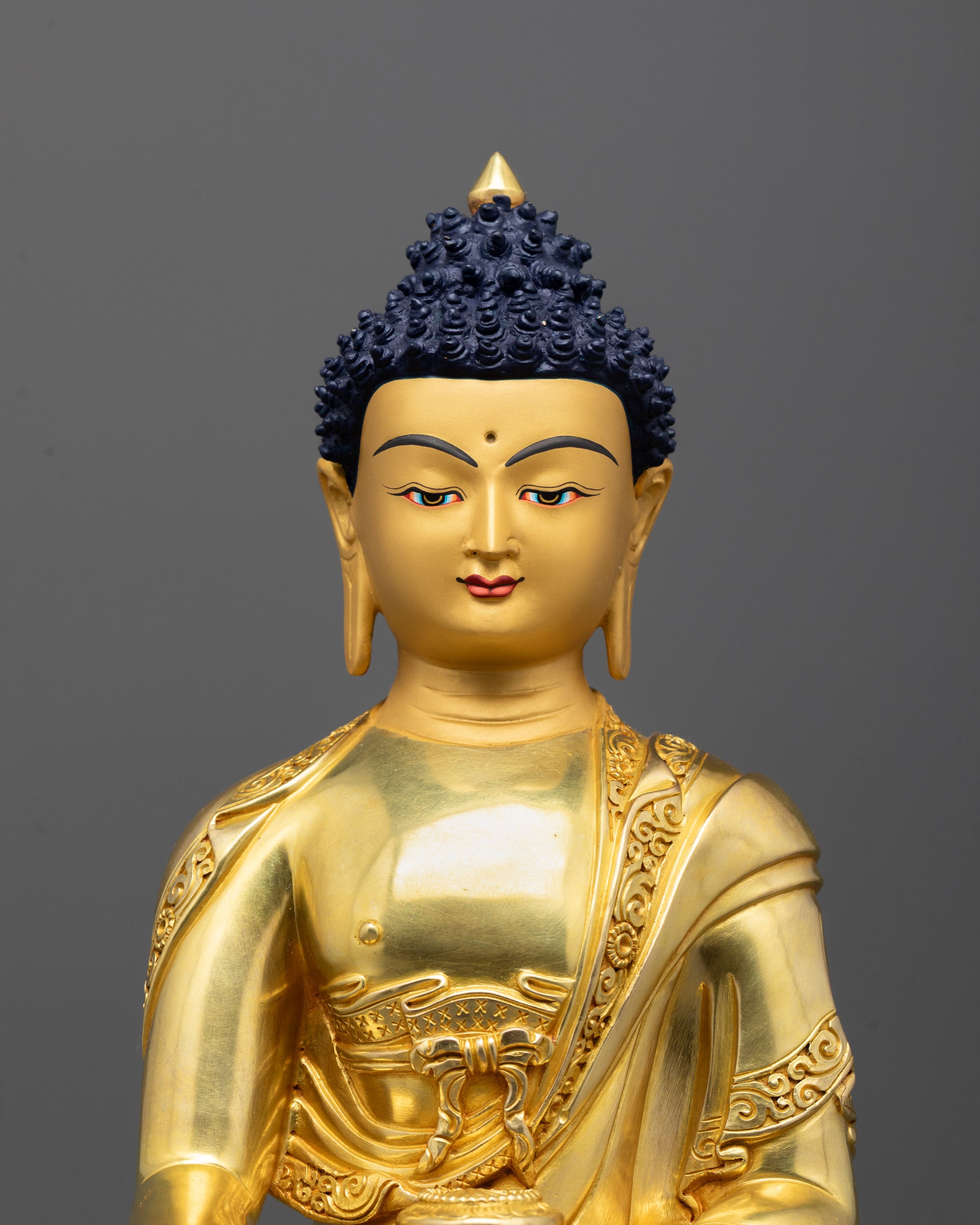 Close up of Buddha Shakyamuni’s gold fire-gilded body showing intricate robe patterns and carvings