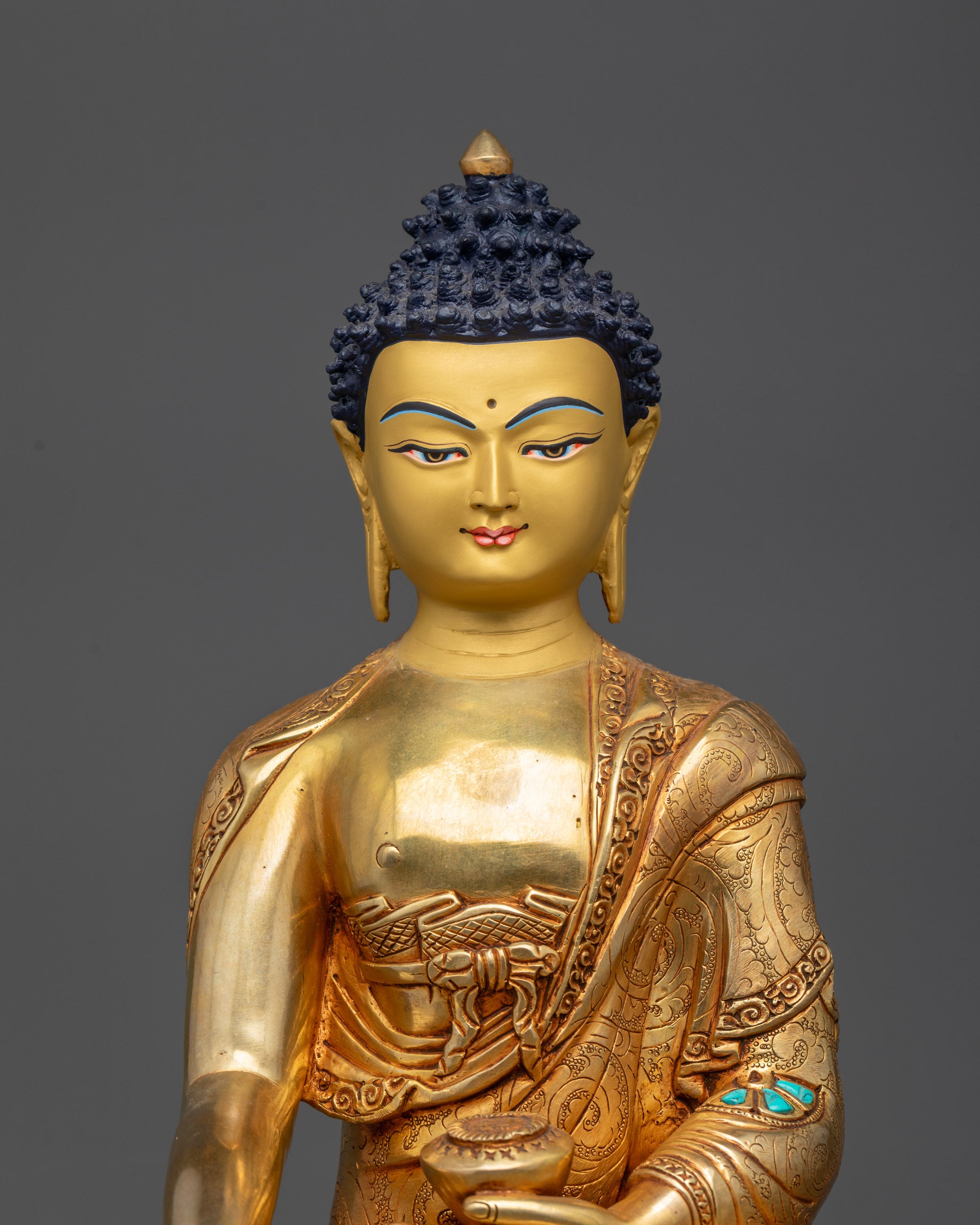 Close up of Buddha Shakyamuni statue showing intricate carved garments and serene expression