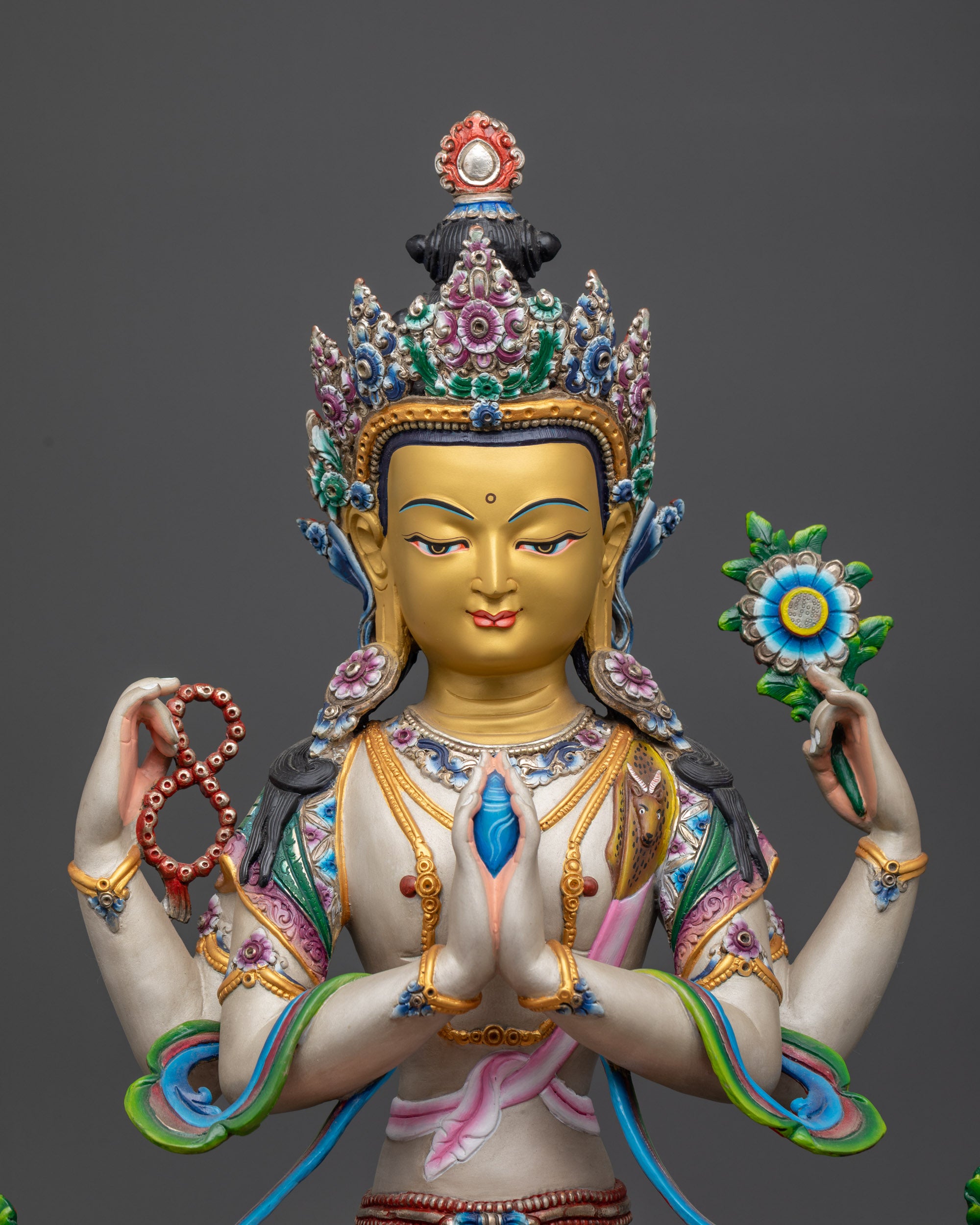 Close up of Chenrezig Statue showing painted robes and lotus throne details