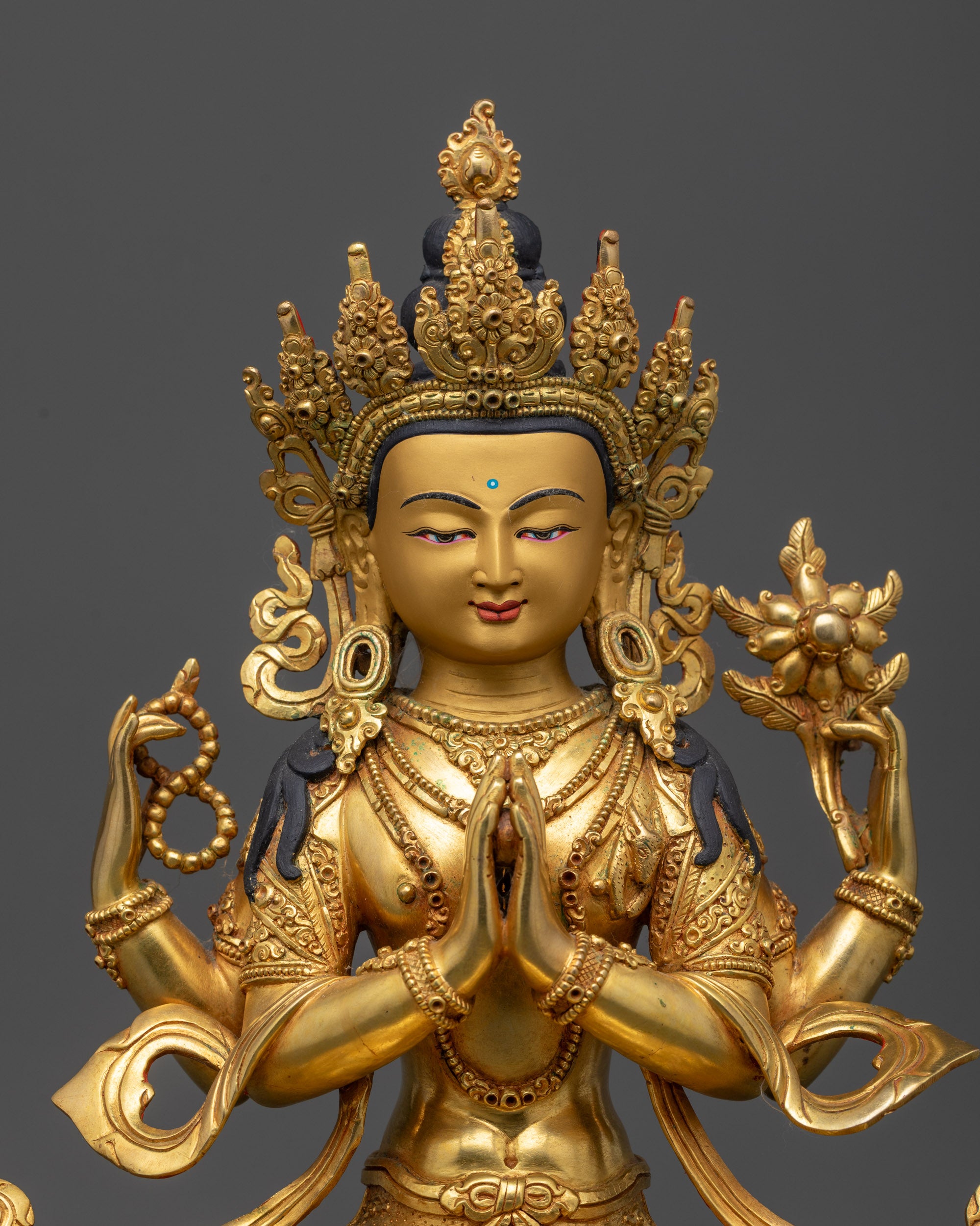 Close up of Chenrezig’s five-jeweled crown, jewelry, and intricate carved robe details