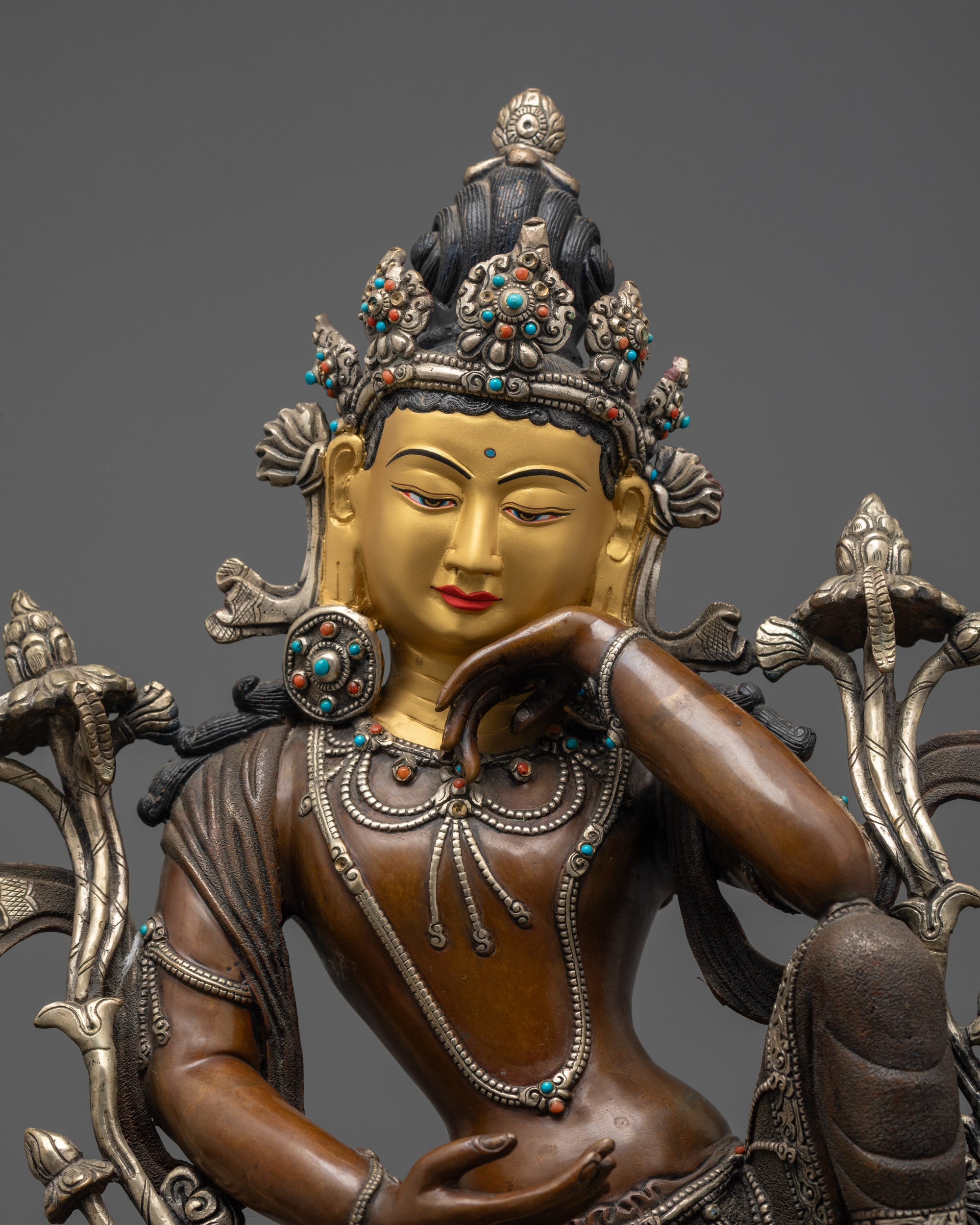 Close up of Chenrezig’s semi-precious stone crown and jewelry with intricate details