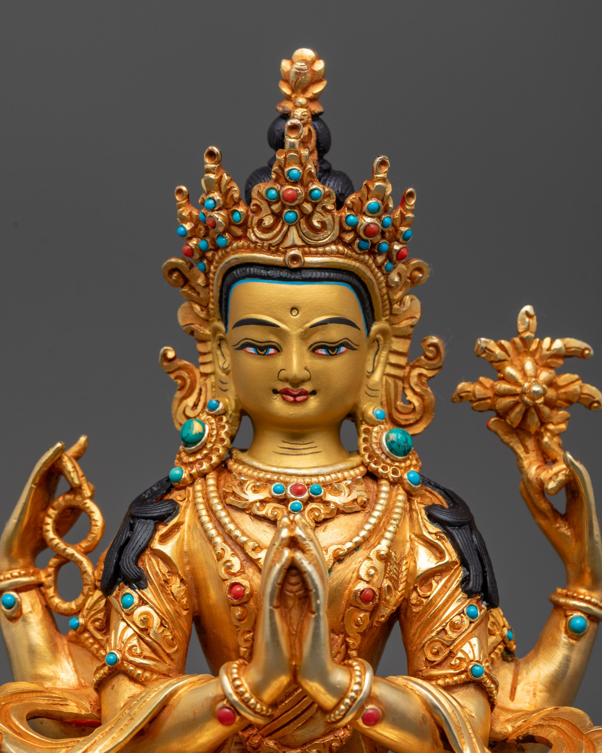 Close up of Chenrezig sculpture showing hand-carved patterns and semi-precious stones