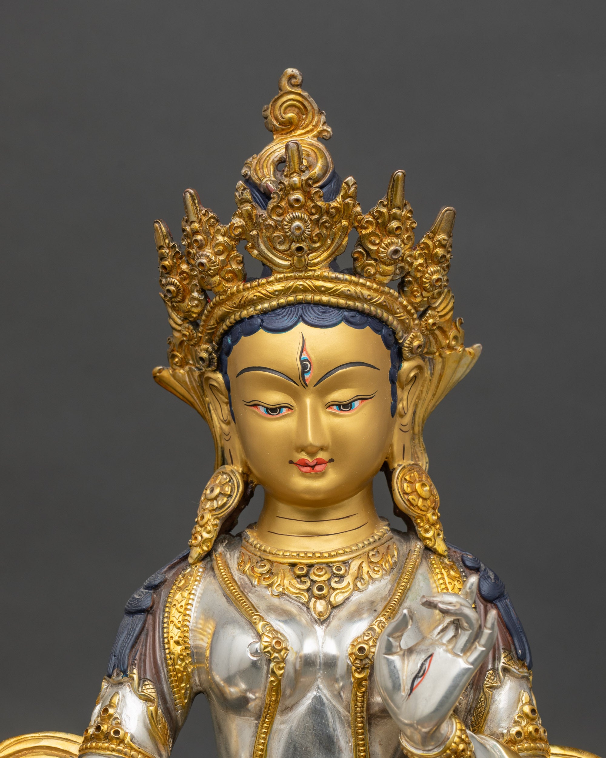 Close up of Dukar Sitatapatra statue silver plated body with gold ornaments Nepal Buddhist sculpture